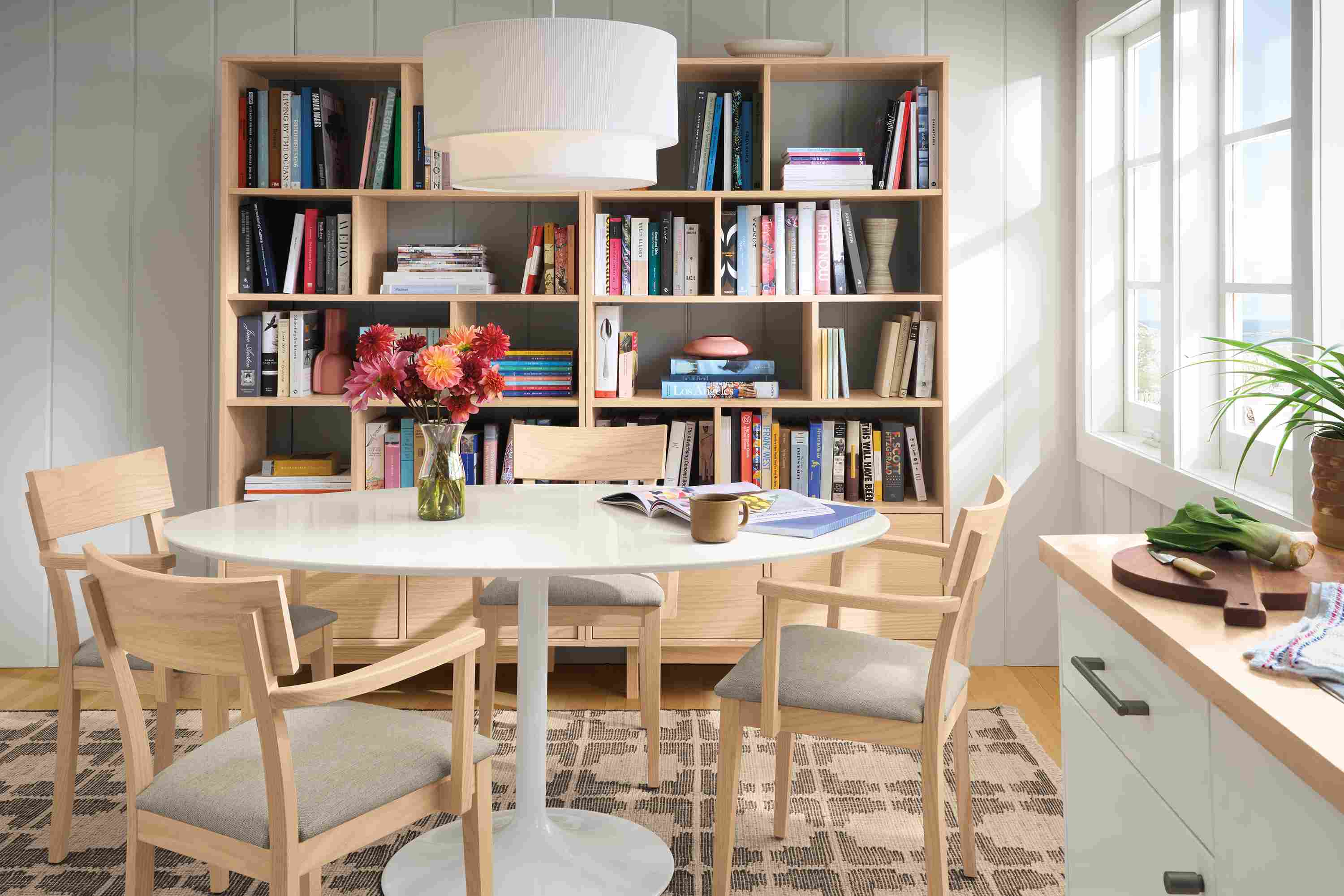 Dining room with Aria 60-wide oval table in white with white quartz top and 4 Doyle arm chairs in salt on red oak with Sumner Linen.