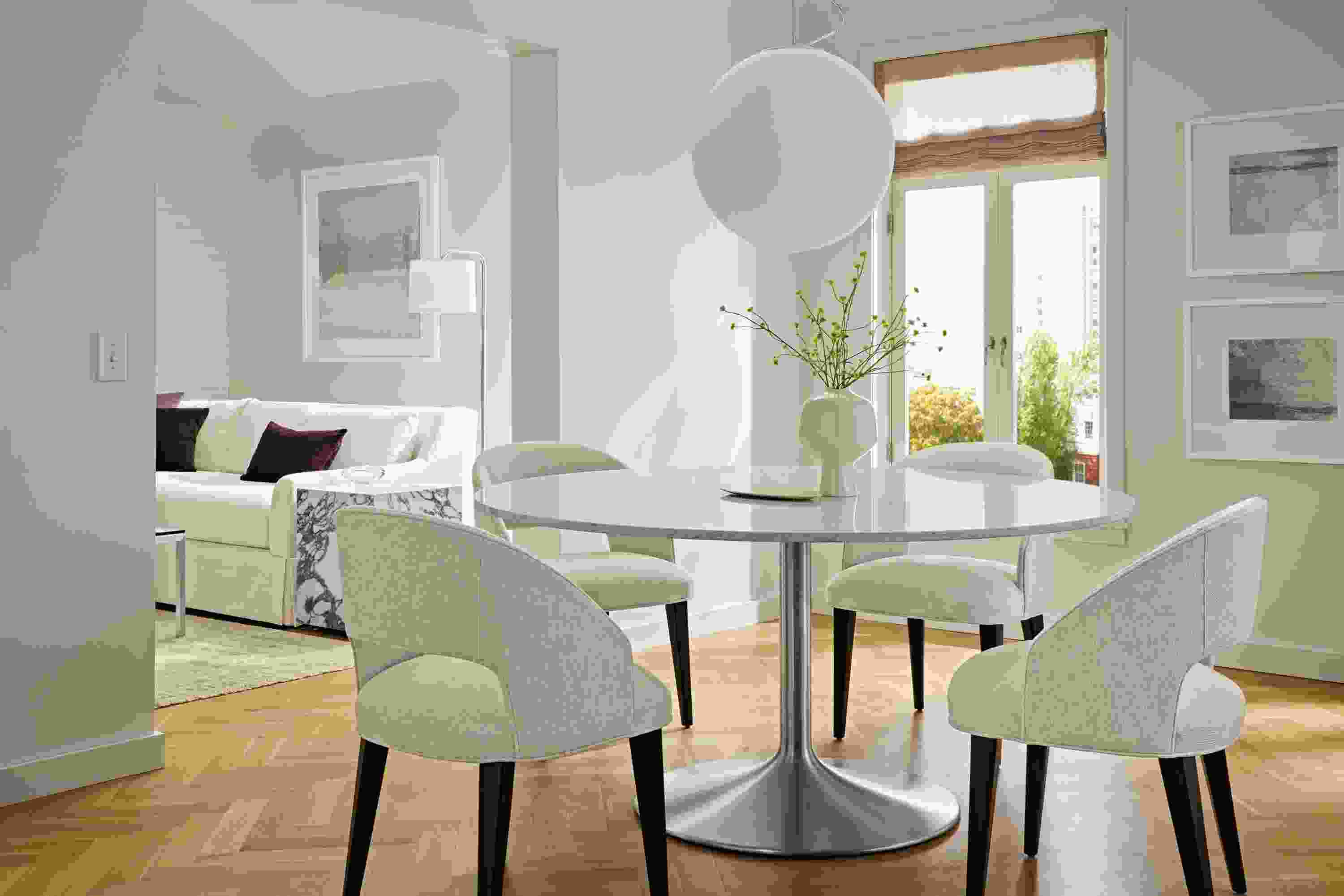 Dining room with Aria 60-round dining table in stainless and marbled white quartz and 4 Esme chairs in Sumner Linen.