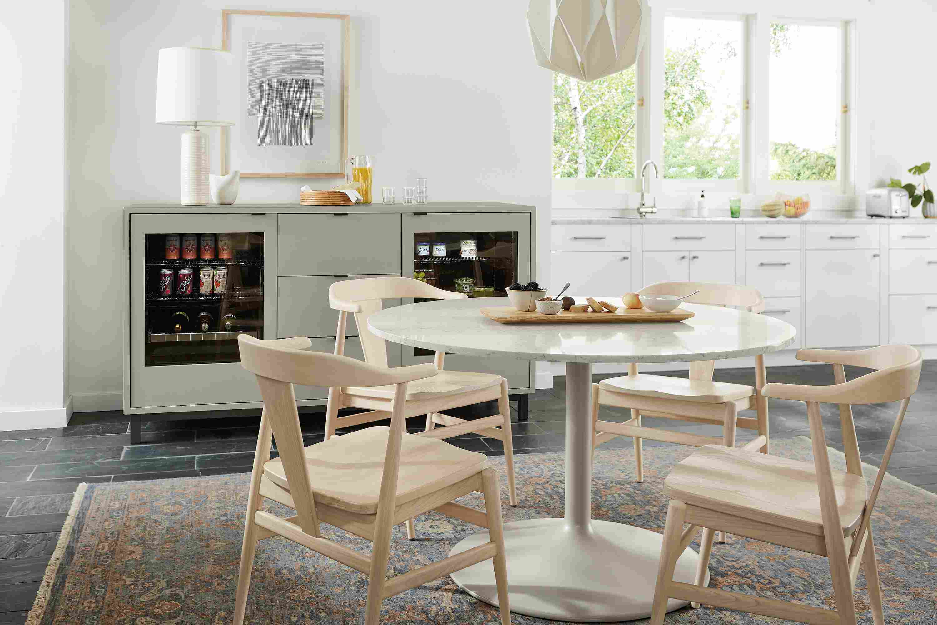 Dining area with Aria 48-diameter table in taupe, Evan arm chairs in sand and 72-wide Copenhagen double fridge cabinet in taupe.