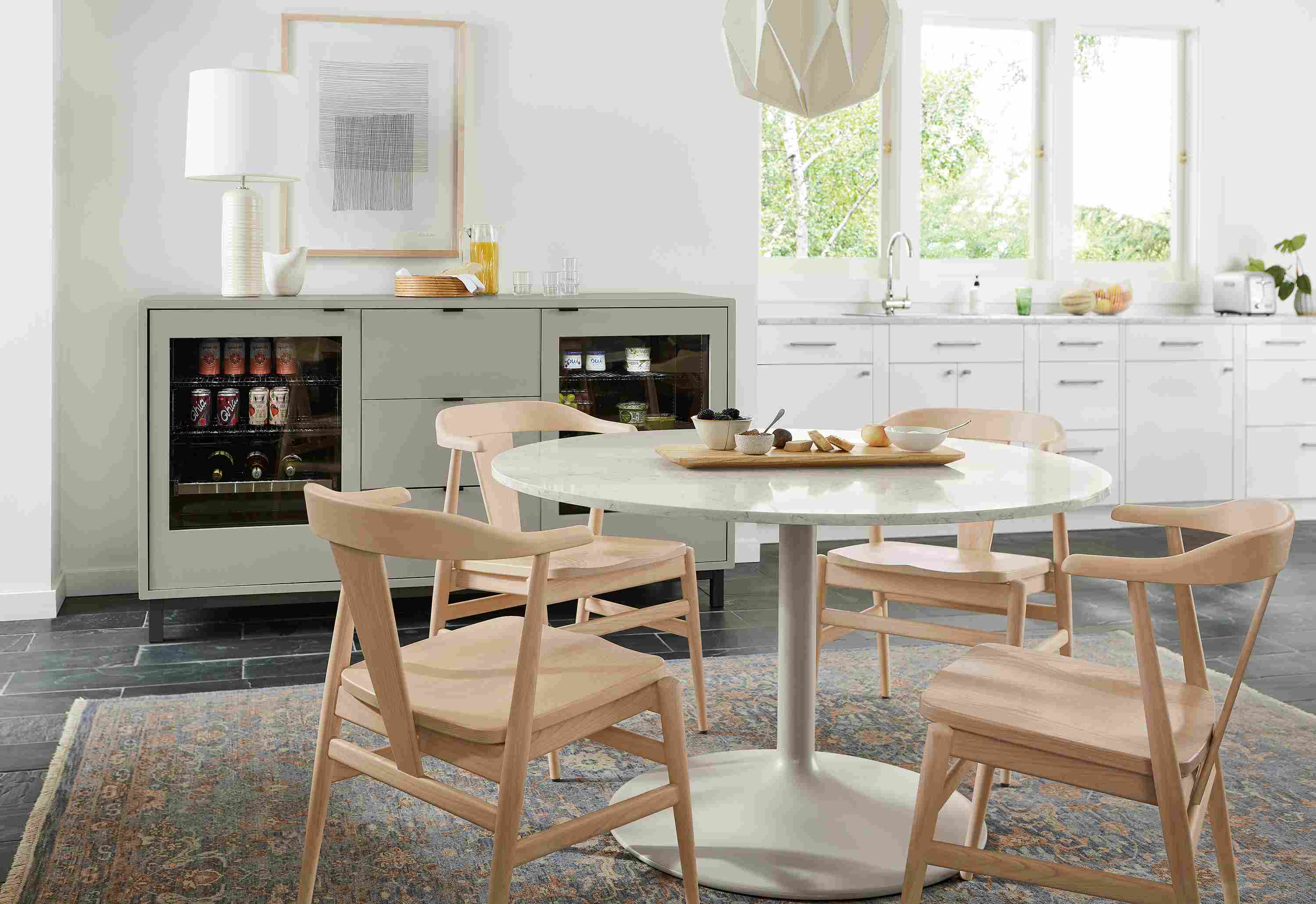 Dining area with Aria 48-diameter table in taupe, Evan chairs in salt and 72-wide Copenhagen double fridge cabinet in taupe.