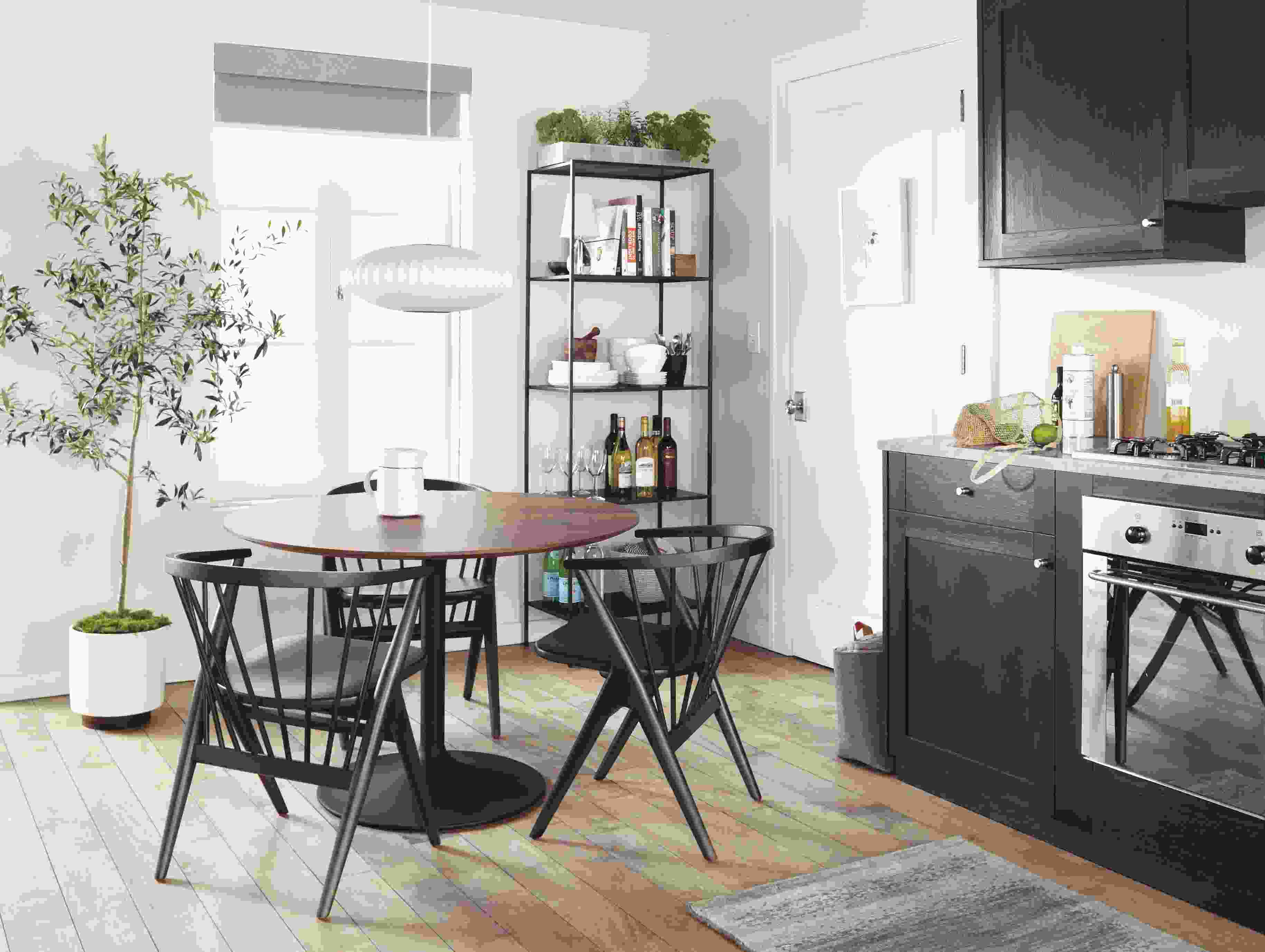 Area dining table with walnut top and soren dining chairs in charcoal stain in kitchen.