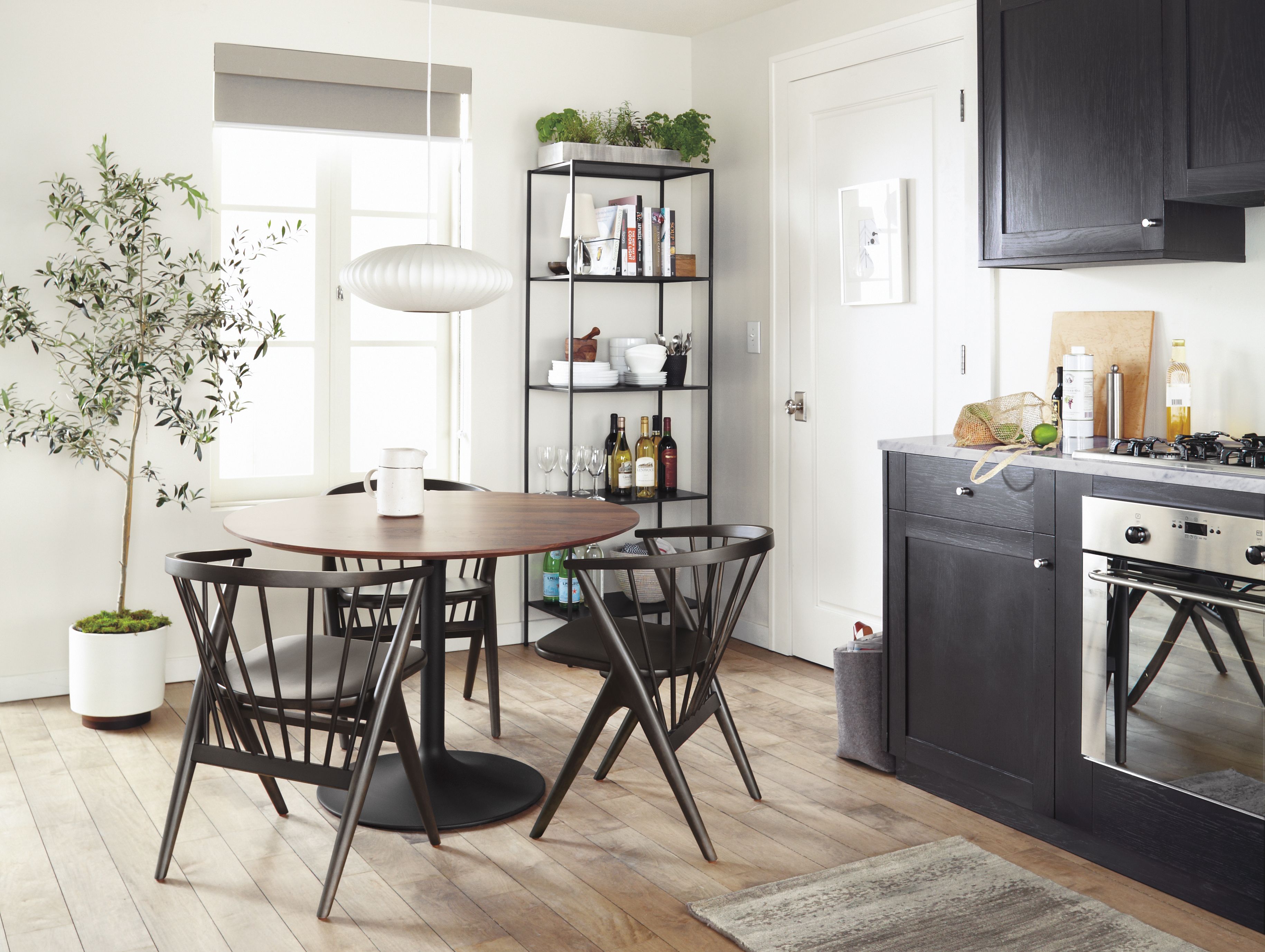 Area dining table with walnut top and soren dining chairs in charcoal stain in kitchen.