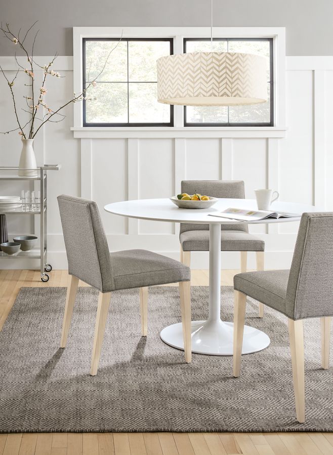 Side view of Aria round dining table in white.