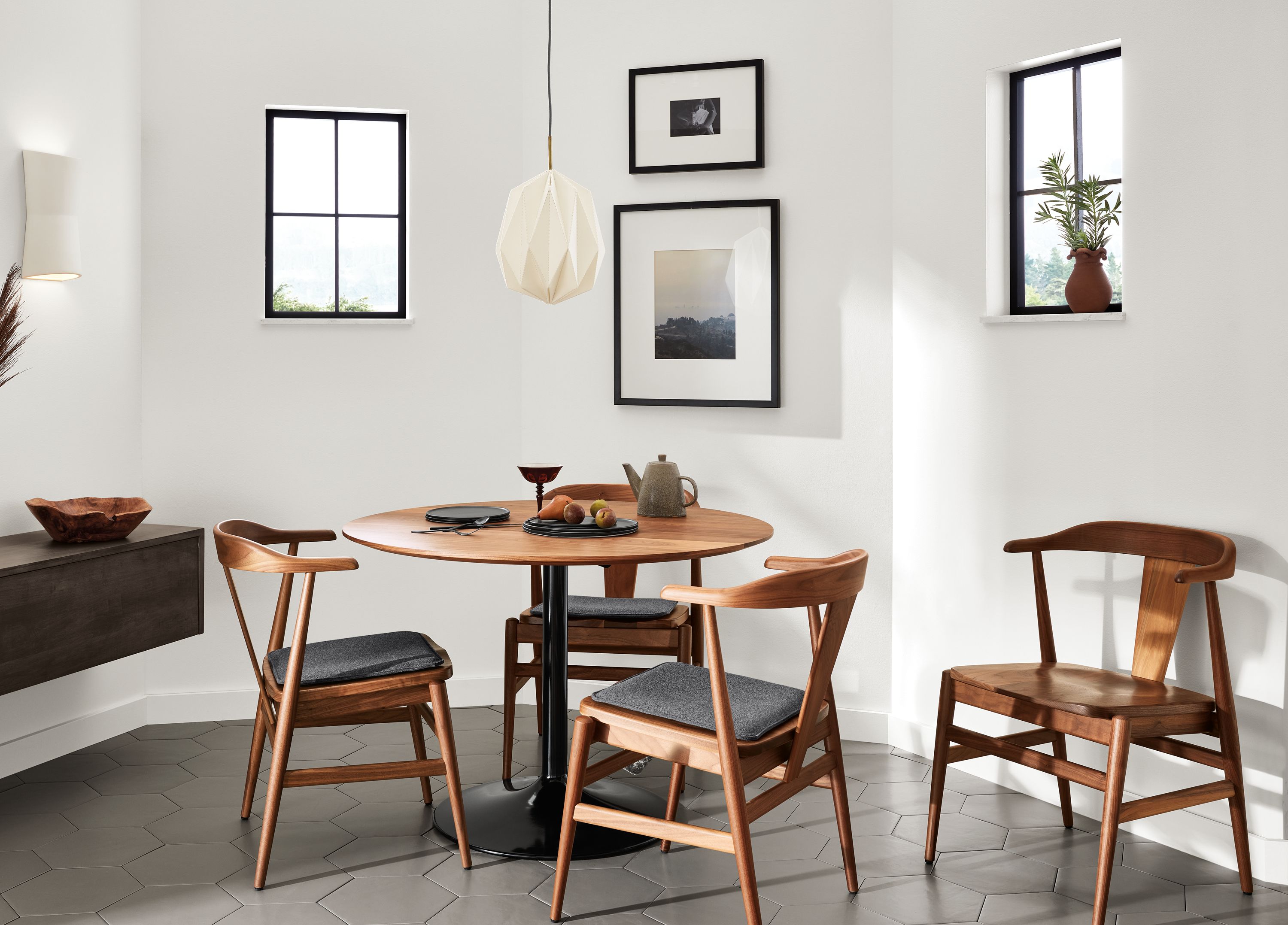 Aria 42-Round Table in onyx with walnut top and Evans chairs with cushions.