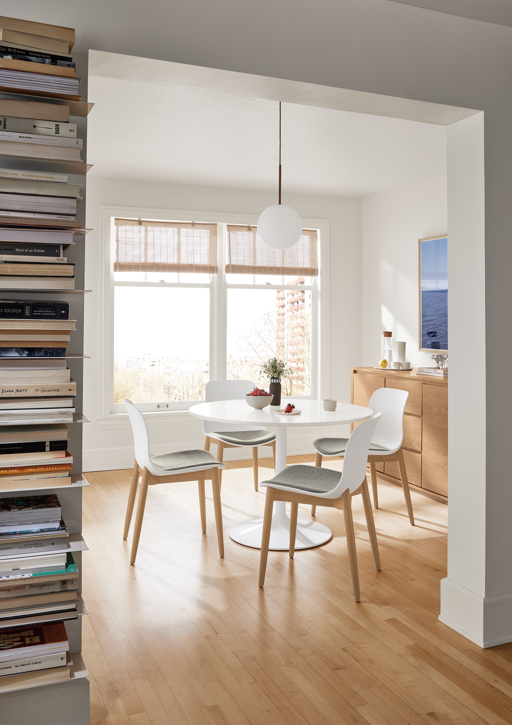 Dining room with Aria round table in white with white quartz top and 4 Pasqual side chairs in Zavin natural and white.