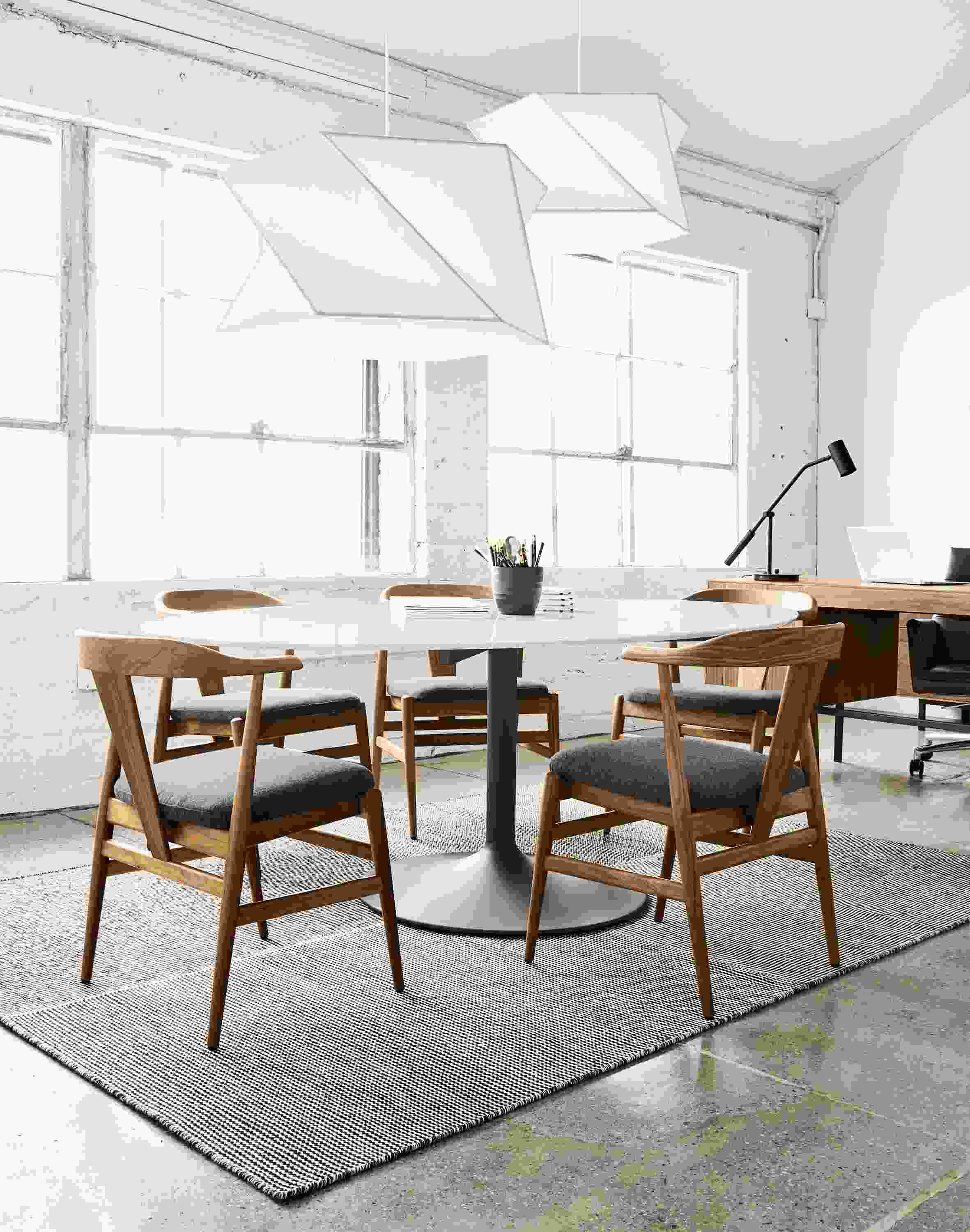 Detail of Aria oval table in graphite and marbled white quartz with five Evan chairs.