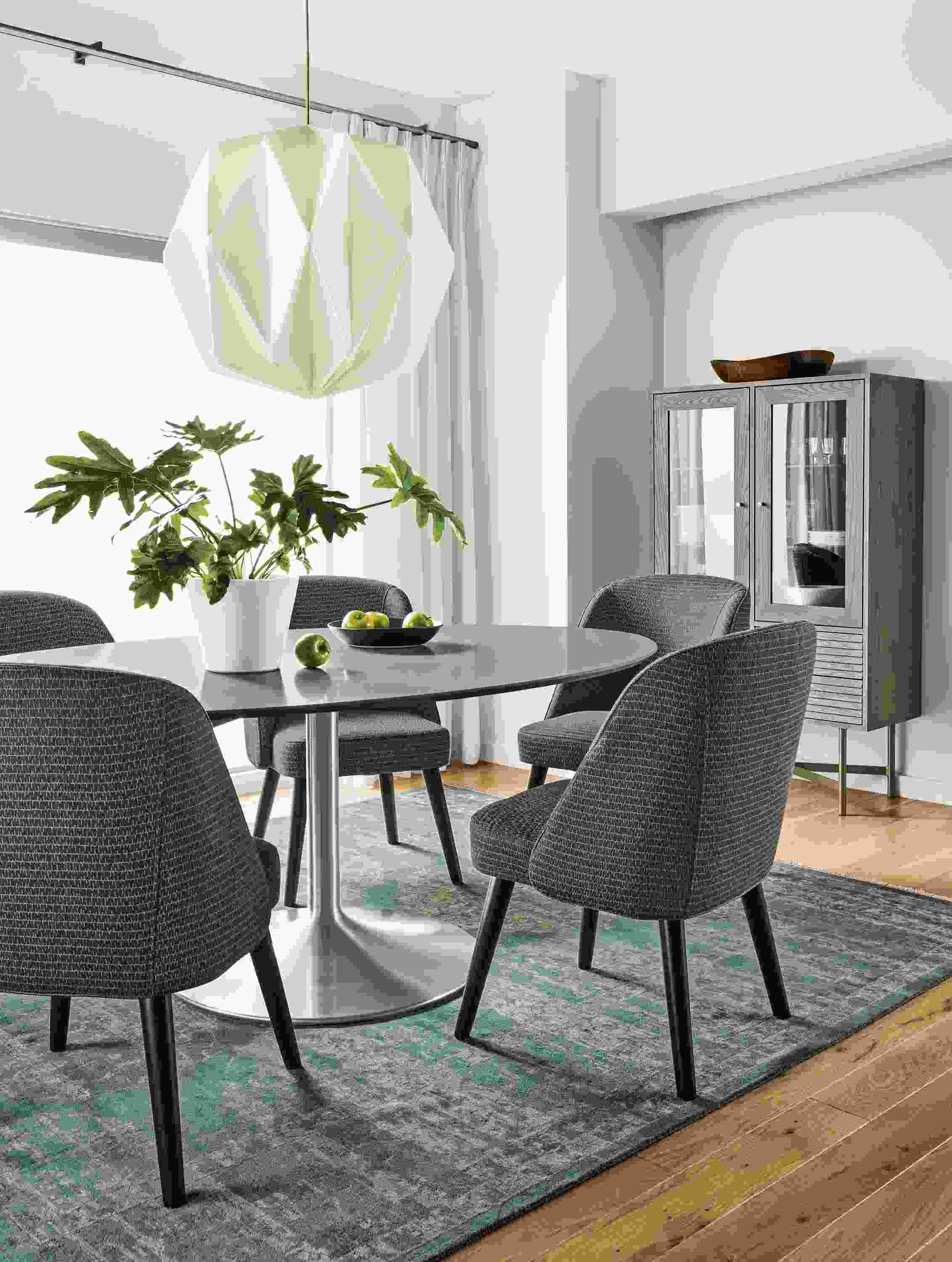Detail of Aria oval table in stainless steel with fog quartz top and Cora side chairs.