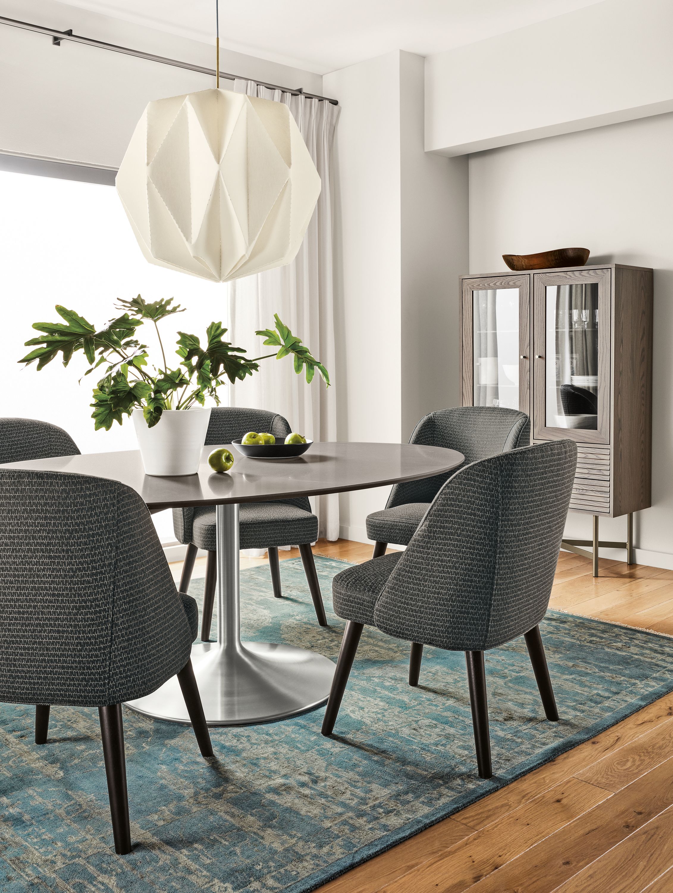 Detail of Aria oval table in stainless steel with fog quartz top and Cora side chairs.