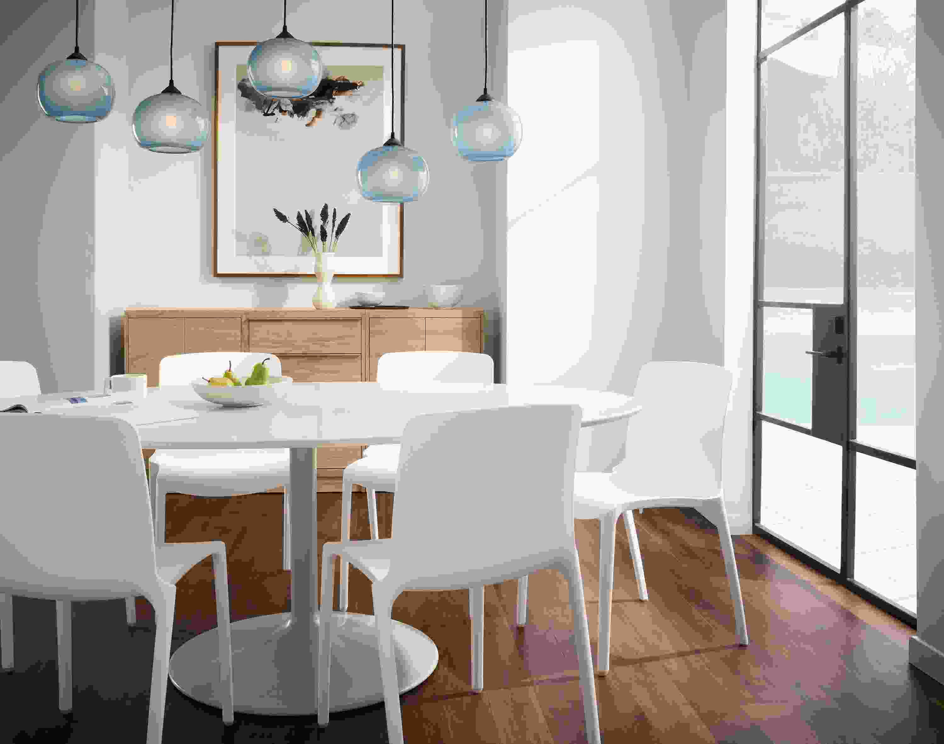 Dining room with white Aria table, Tiffany side chairs in white and gale pendant light set in cloud blue.