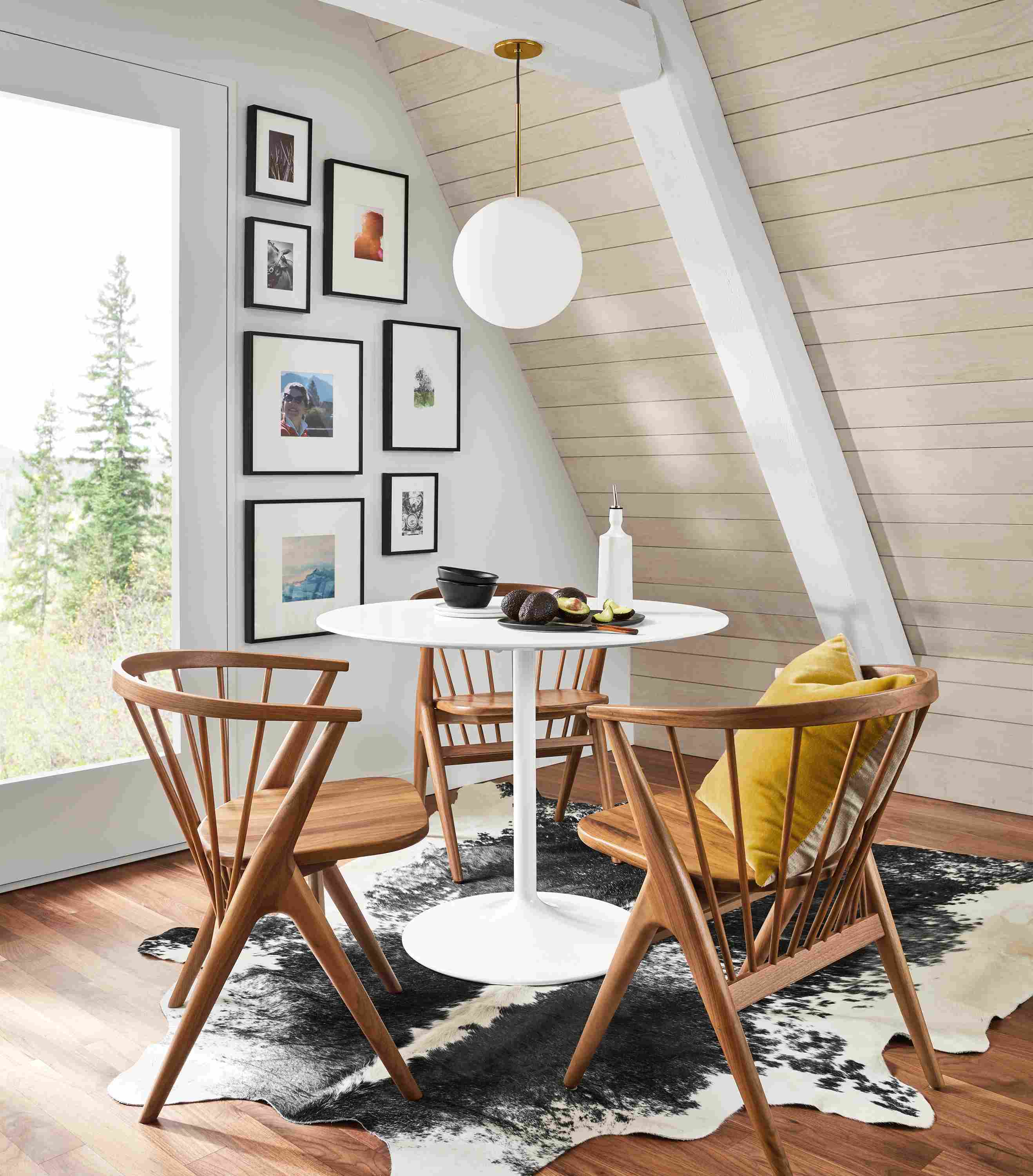 Aria 36-round table in white with 3 Soren arm chairs in walnut in a home dining area.