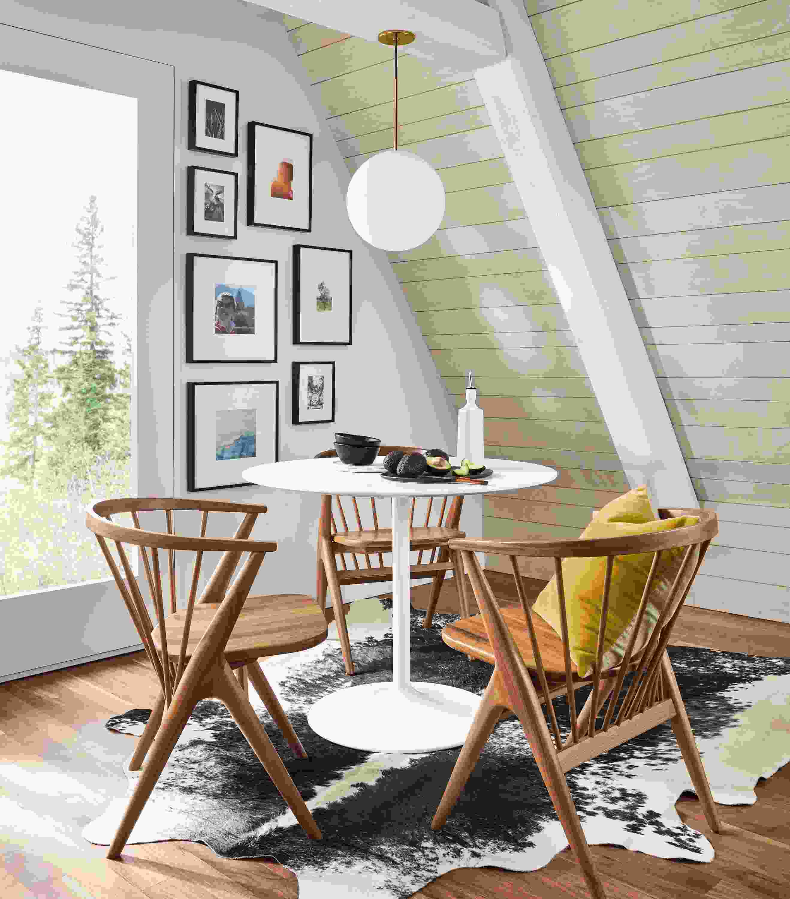 Aria 36-round table in white with 3 Soren arm chairs in walnut in a home dining area.