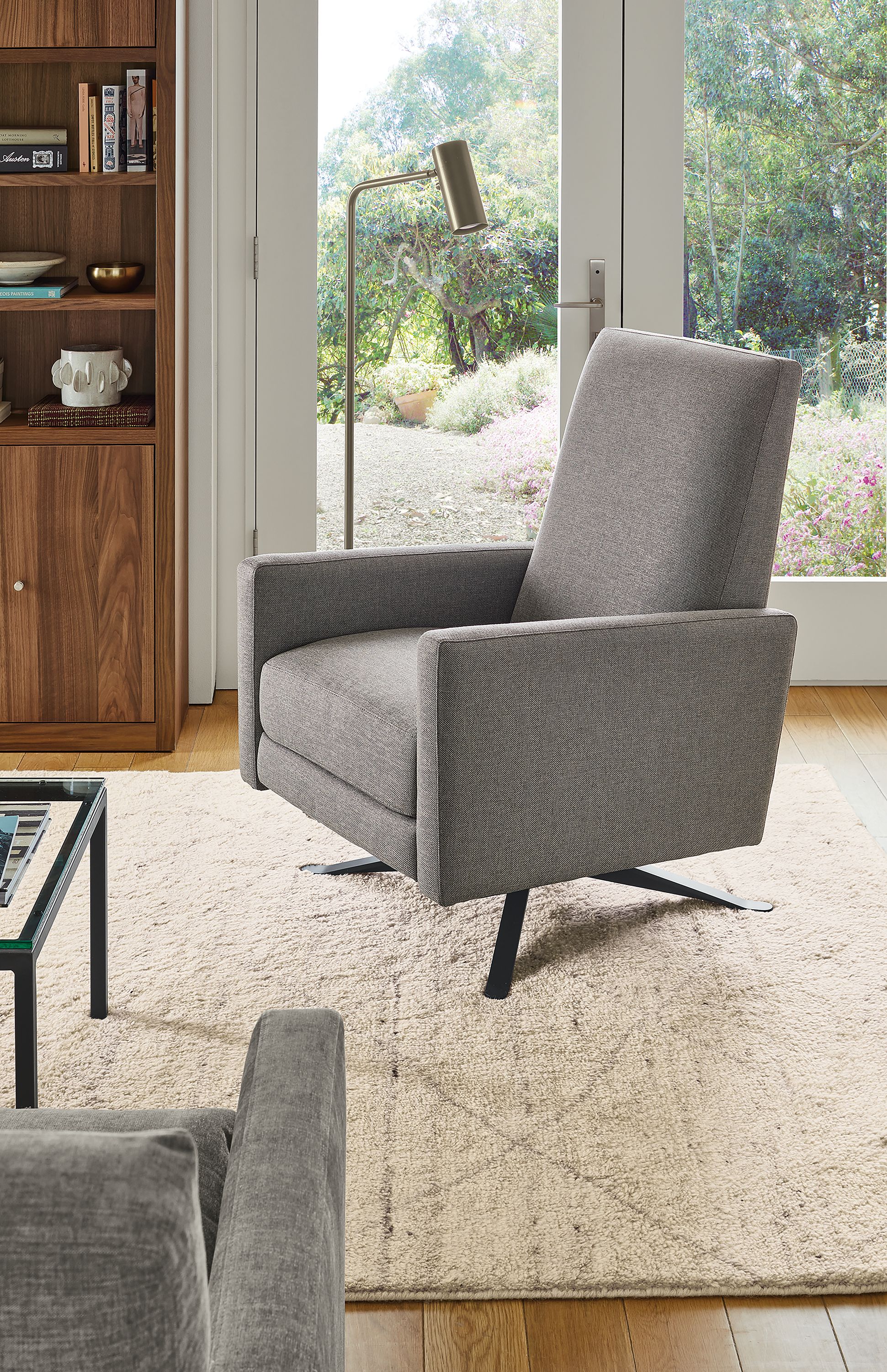 Living area with Arlo Recliner in Sumner graphite fabric and graphite metal base and Kalindi rug in Cement.