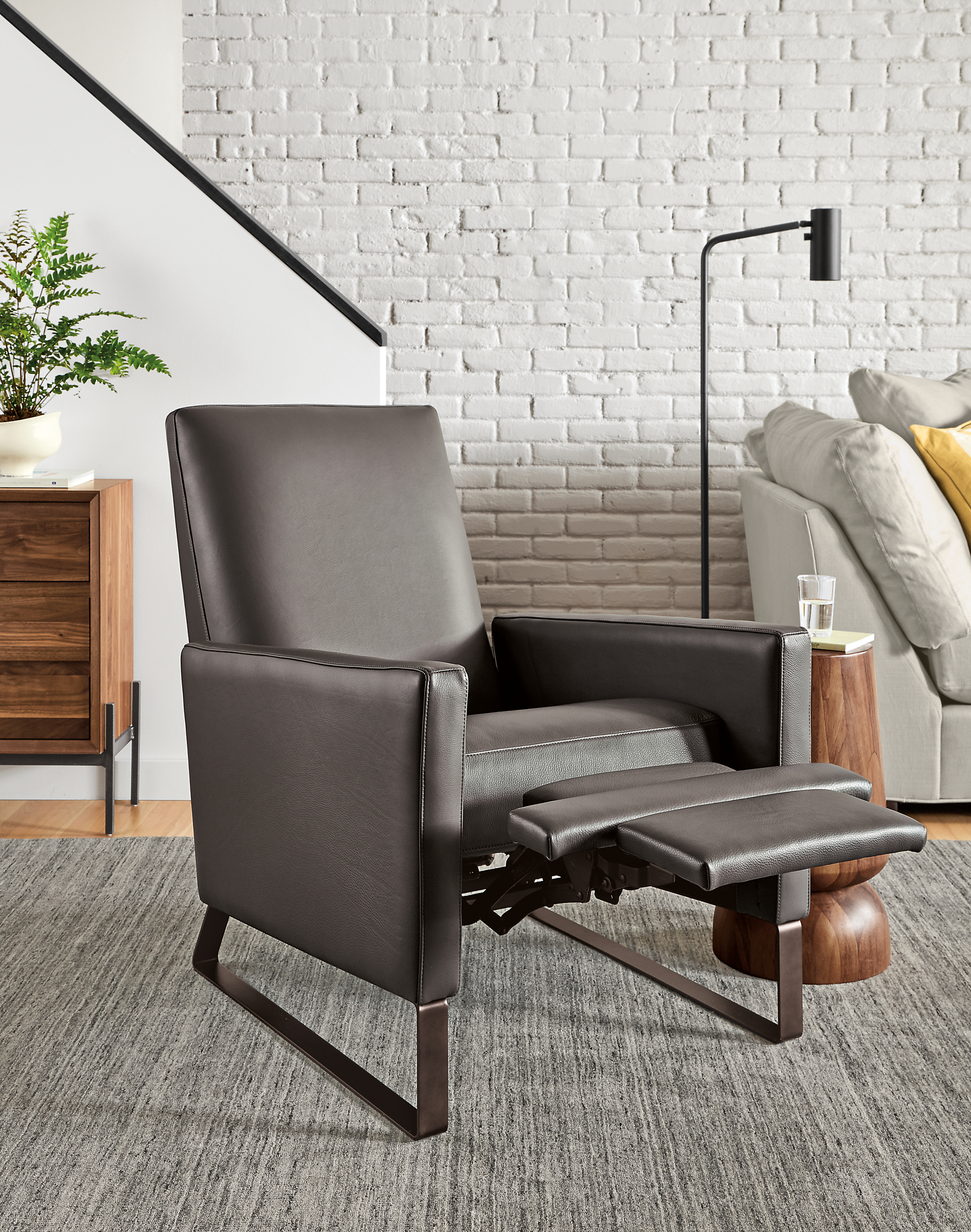 Detail of Arlo Thin-Arm Recliner in Urbino Smoke Leather with steel sled  base with foot rest extended.