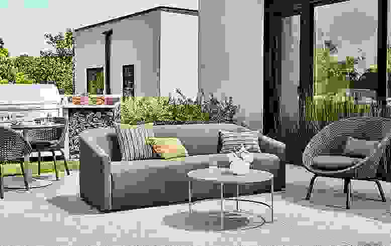Outdoor patio with Arris sofa in Mist Charcoal, Flet Chair in slate and Slim coffee table in taupe.