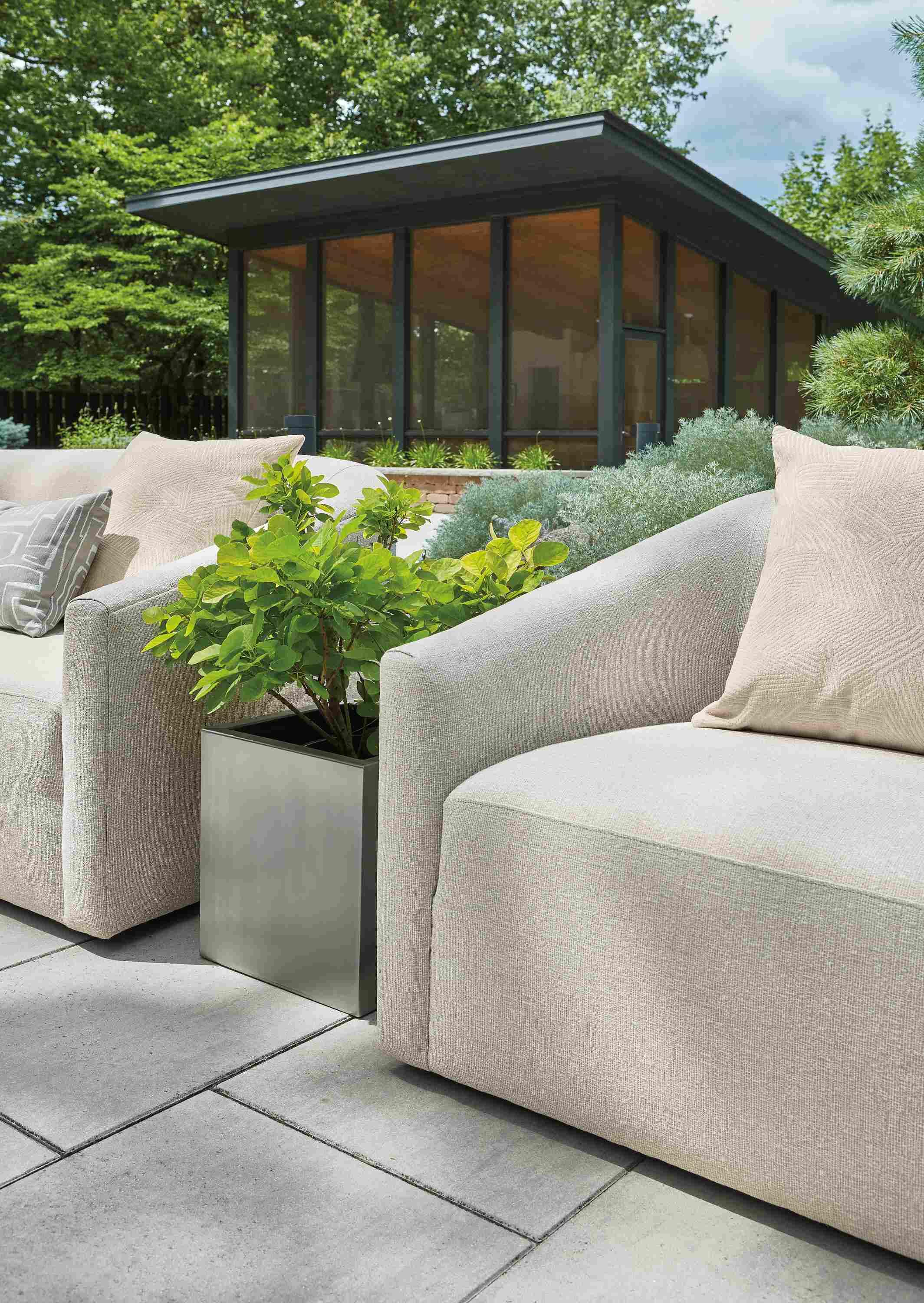 Detail of Two Arris Outdoor Sofas in Nevan Grey and Terrace square planter in stainless steel.