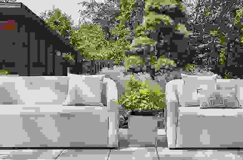 Two Arris Outdoor Sofas in Nevan Grey and Terrace square planter in stainless steel.