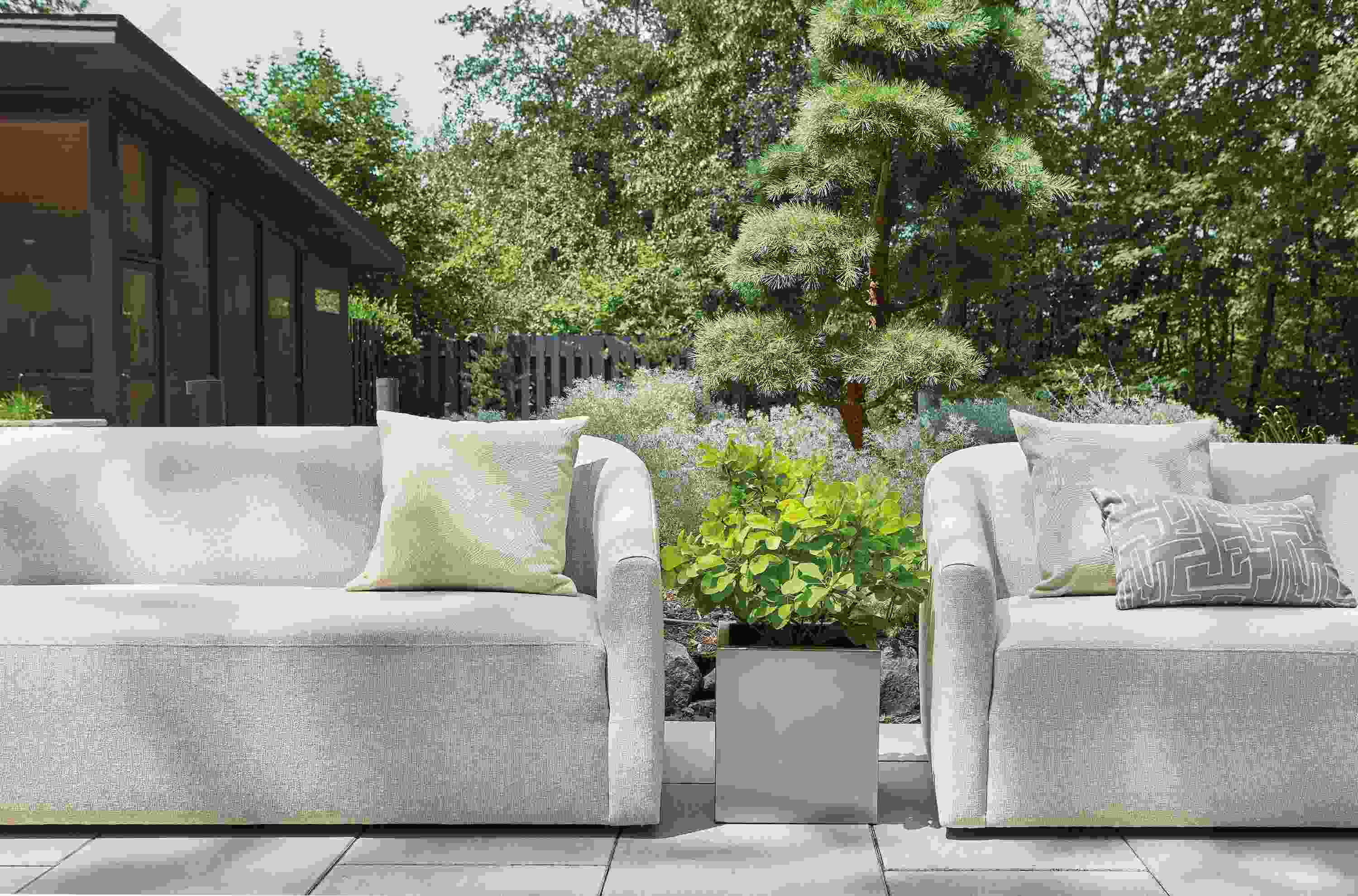 Two Arris Outdoor Sofas in Nevan Grey and Terrace square planter in stainless steel.