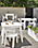 outdoor space with aspen dining tables, aspen counter table, aspen stools and chairs in white.