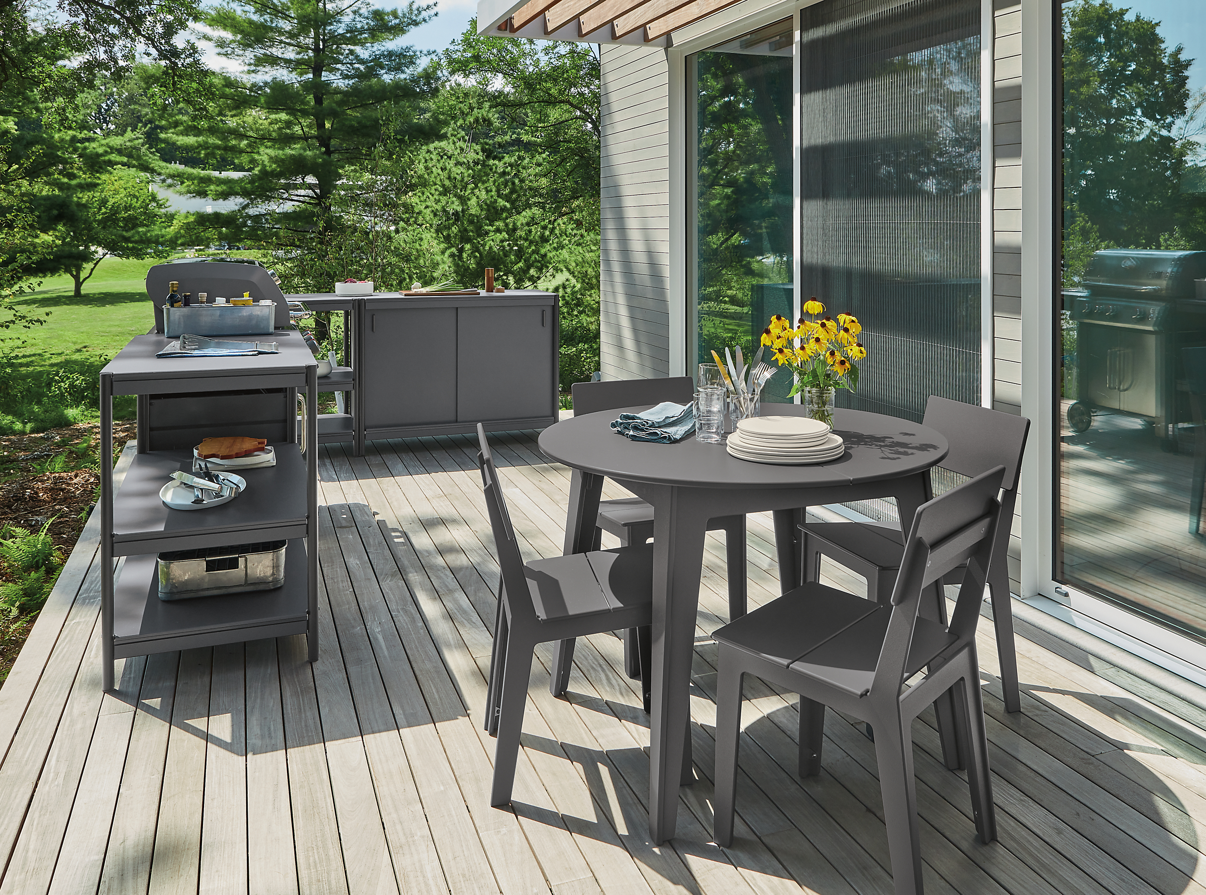 Outdoor space with Granger kitchen island and grill, Aspen table, ASpen chairs.