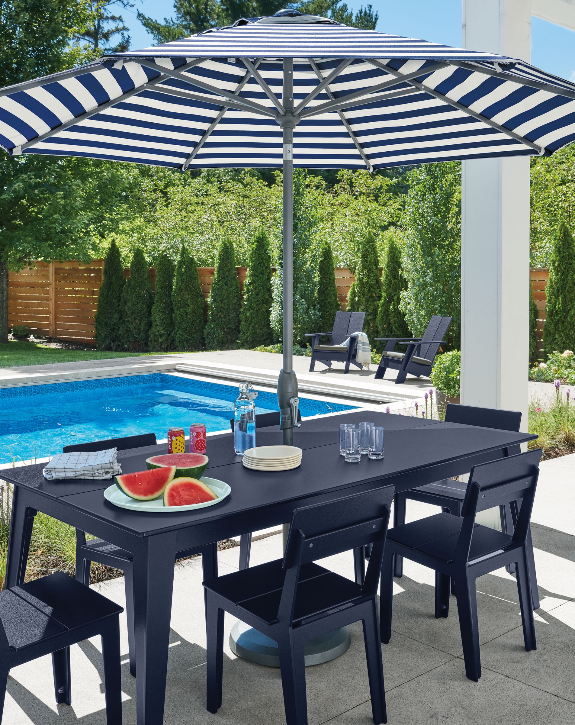 Aspen outdoor dining table and chairs in navy with Oahu 9 foot umbrella in Watts Navy fabric.