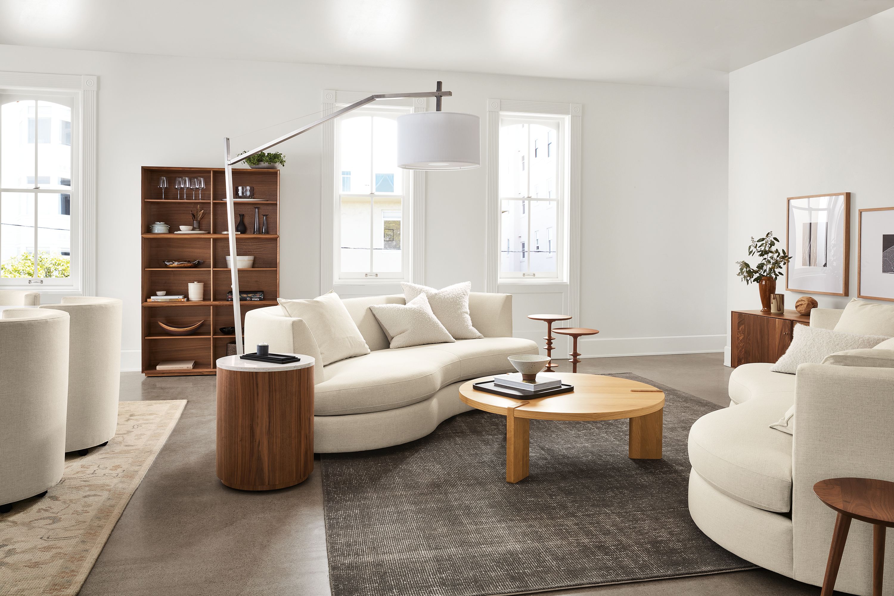 Living room setting with Astaire 94-inch Bench Cushion Curved Sofa in Sumner Fabric, Hanover 48-round Coffee Table in White Oak and Samar 9'x12' Rug in Charcoal.