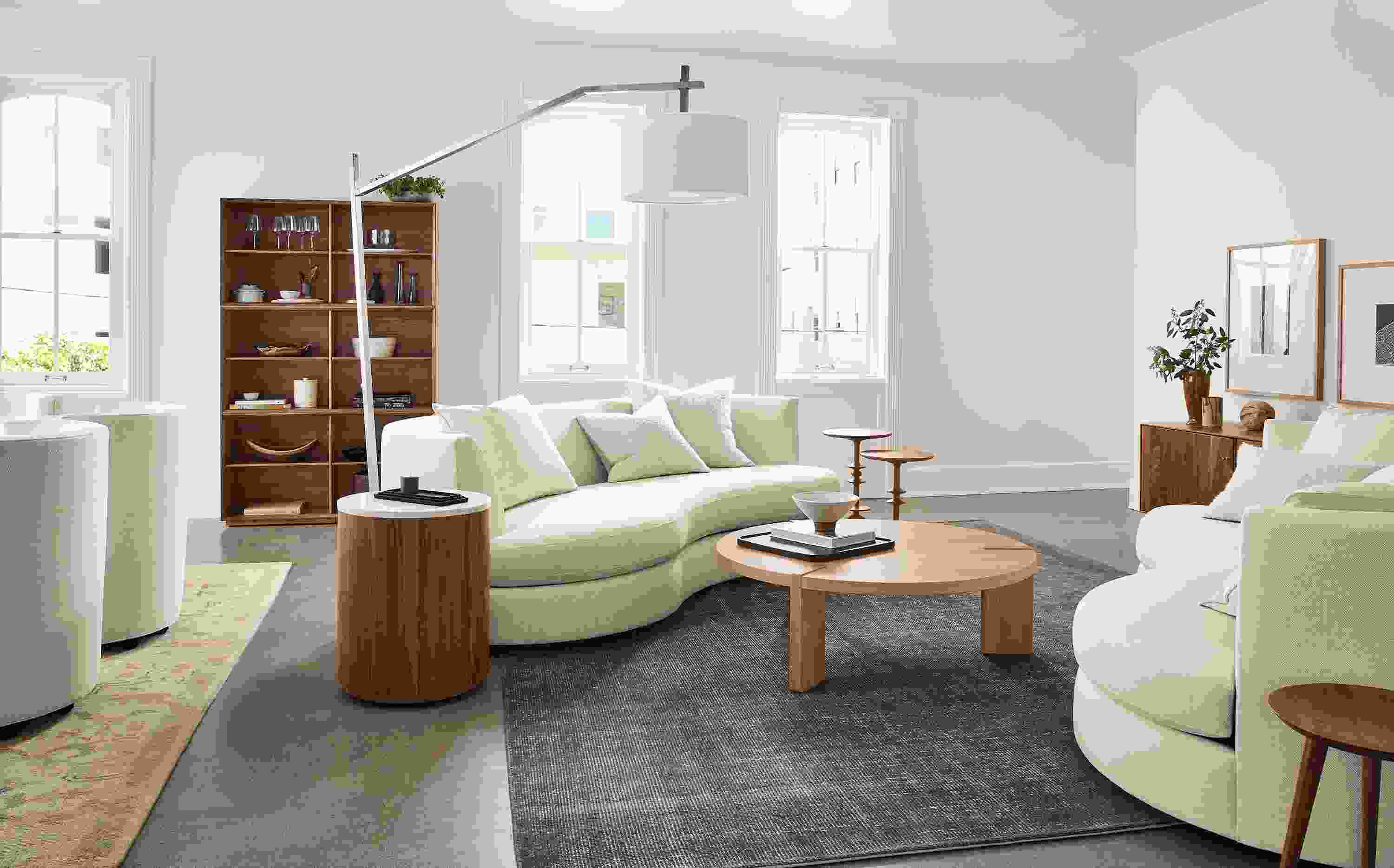 Living room with 2 Astaire Bench Cushion Curved Sofas in Sumner Ivory and Hanover 48-round Coffee Table in rye on red oak.