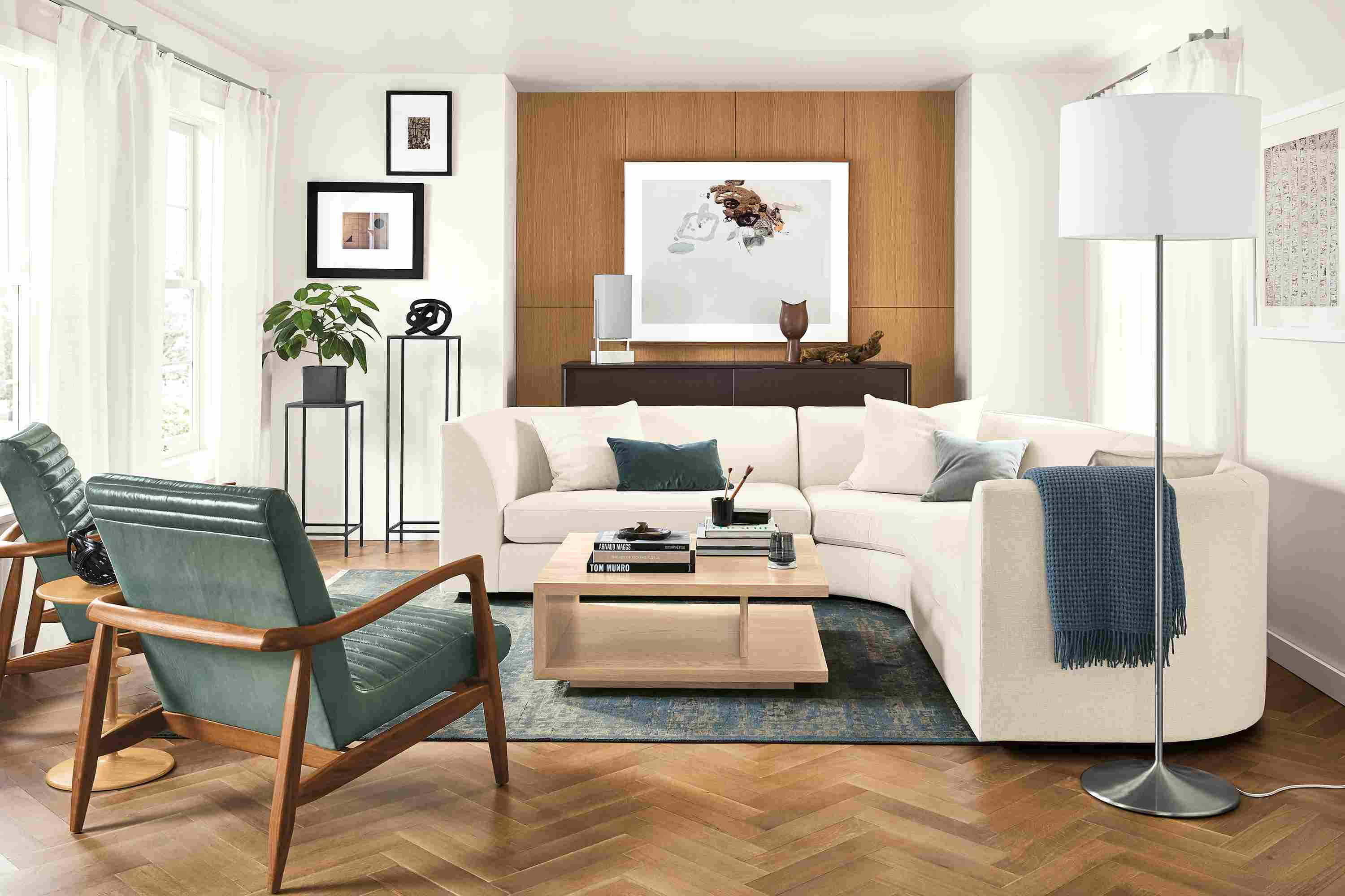 Living room with astaire 3-piece curved sectional in sumner ivory, 2 callan chairs in vento teal leather and graham table in salt.