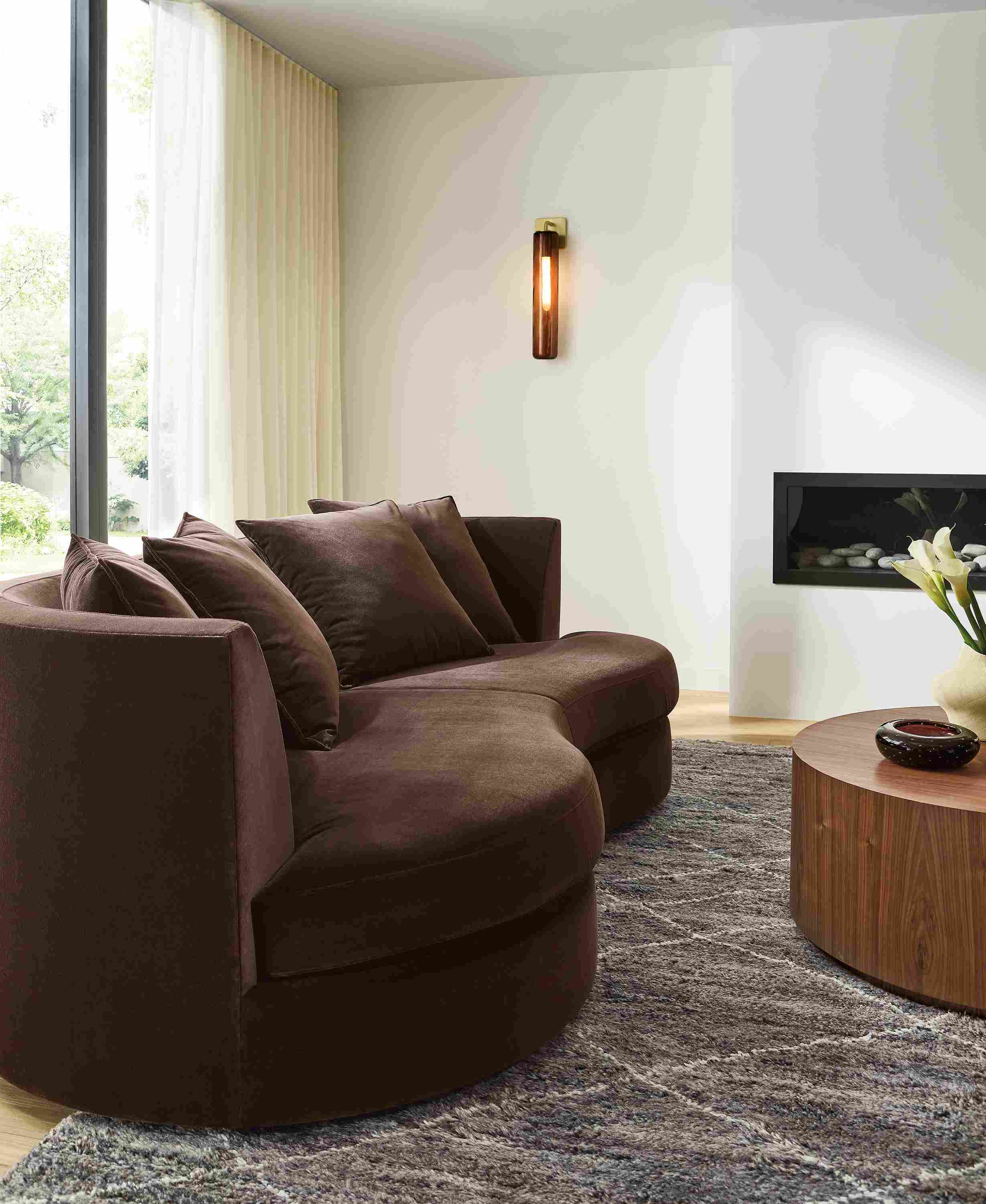 Living room with Astaire 94-wide bench cushion curved sofa in Redding Espresso and Kalindi 8 by 10 rug in charcoal.