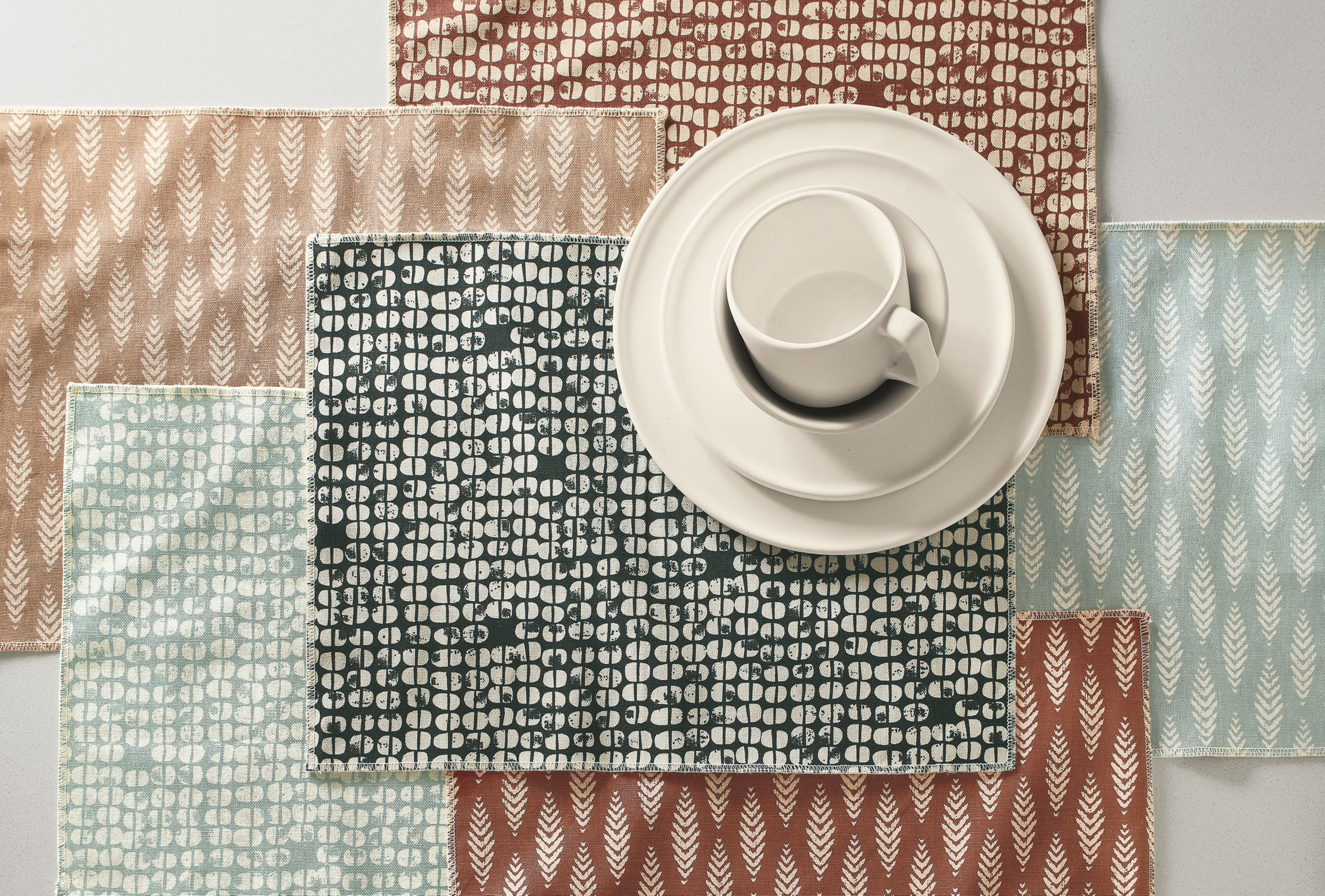 tabletop with 3 astoria placemats and 3 ashwin placemats layered.