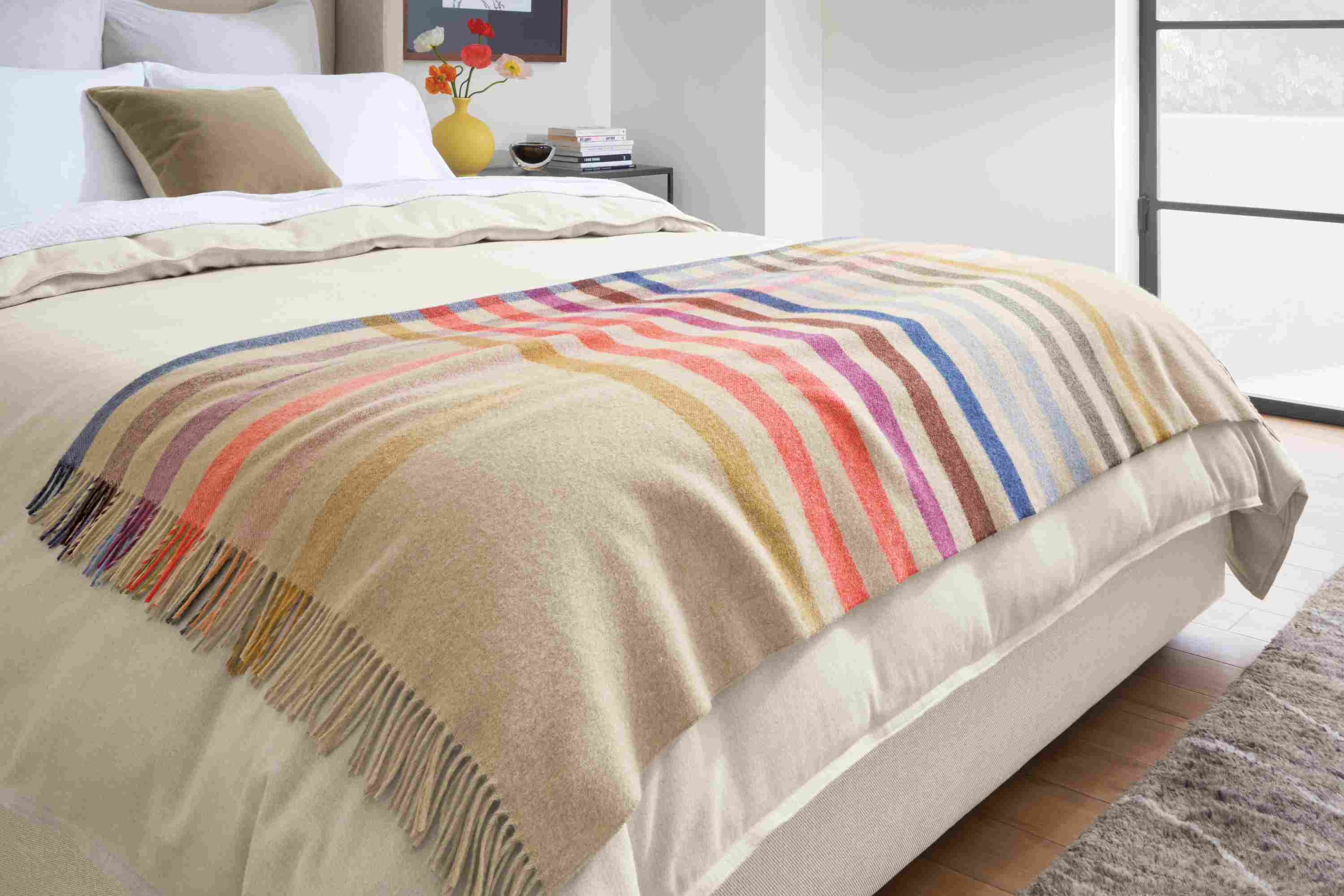 Detail of Audrey multicolor throw blanket on Marlo queen bed and Heathered flannel duvet cover and sham in oatmeal.