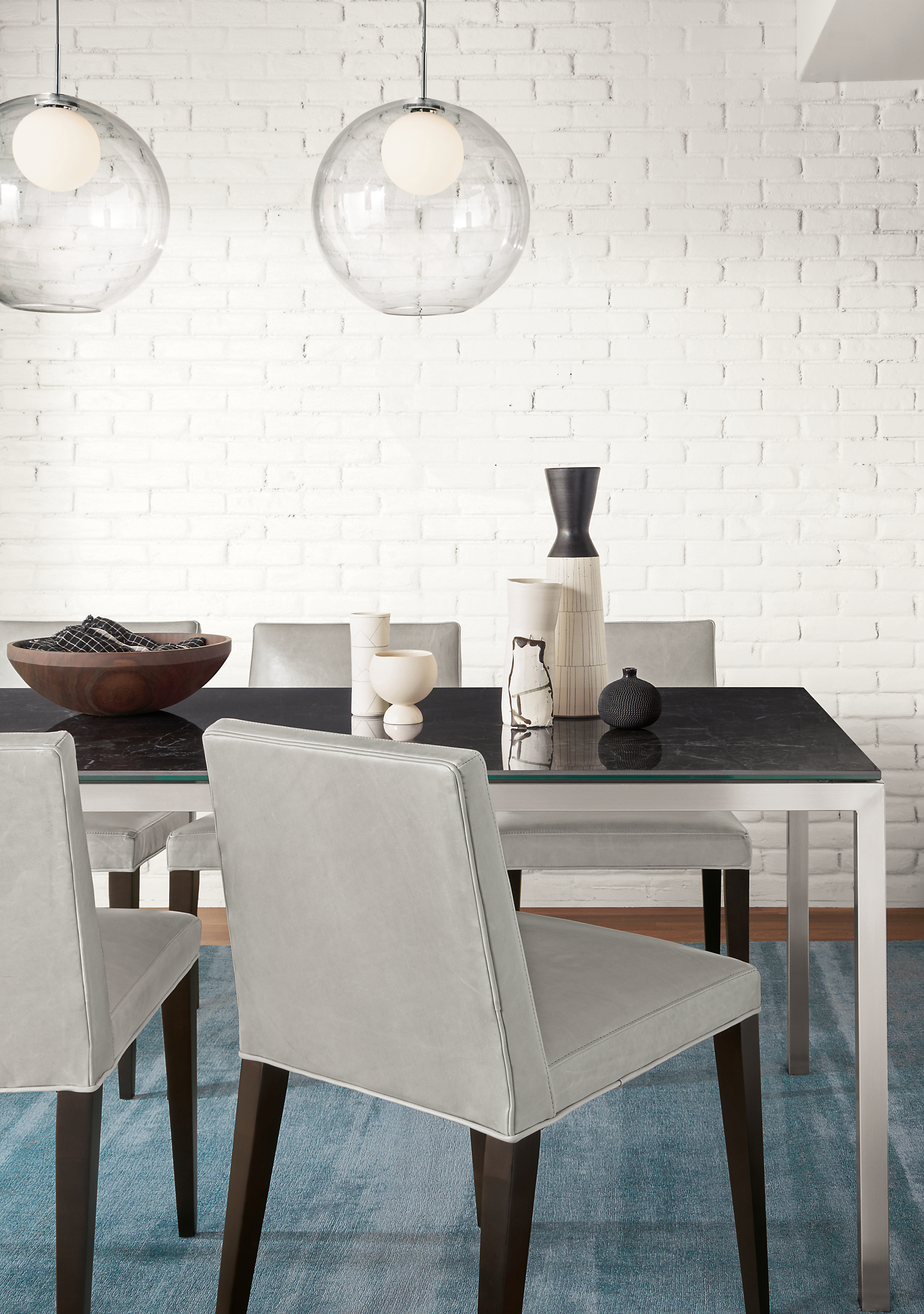 Detail of Ava side chair in Vento Grey leather at dining table.