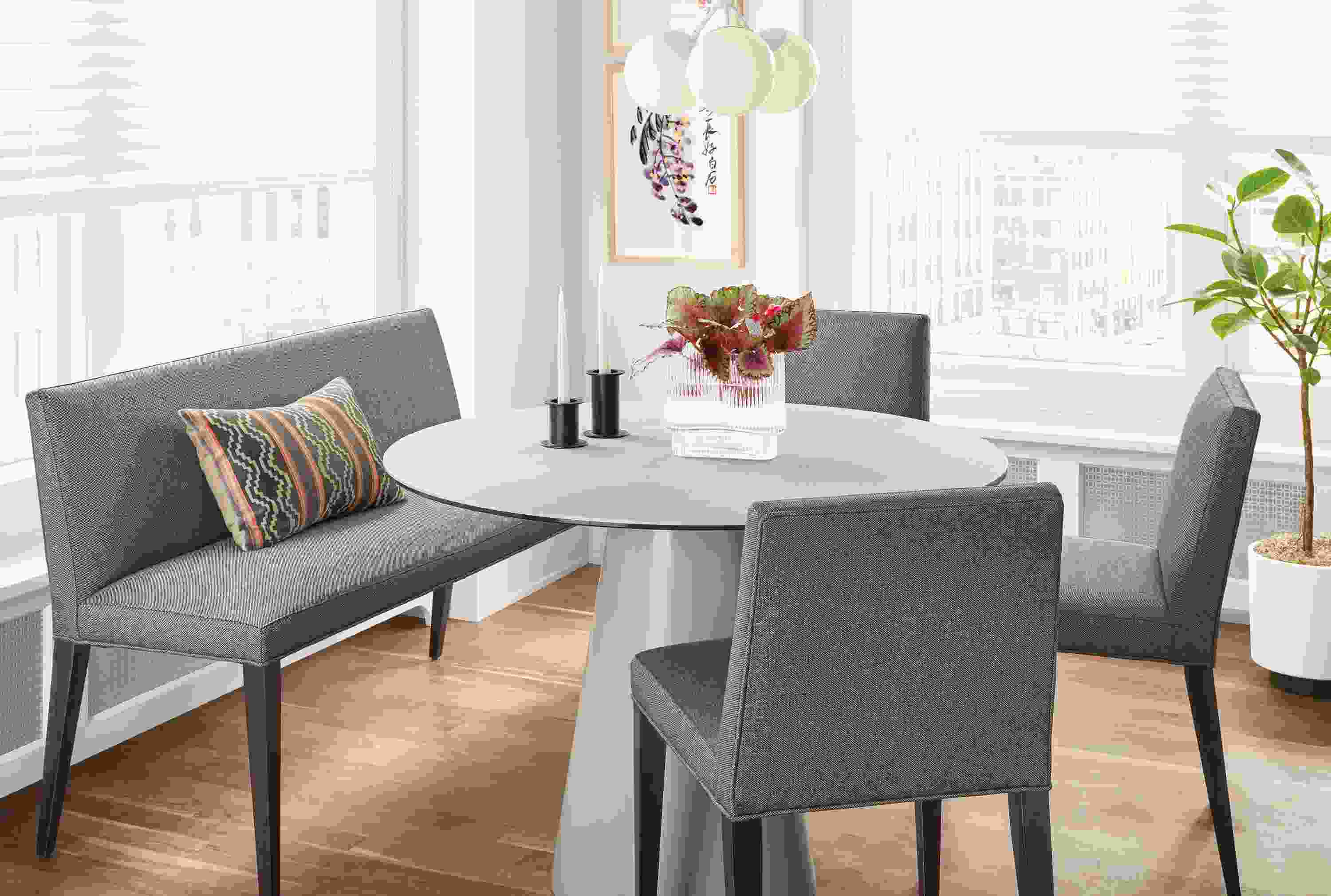 Detail of Ava bench in Sumner Graphite fabric at round table in kitchen with 3 Ava chairs.