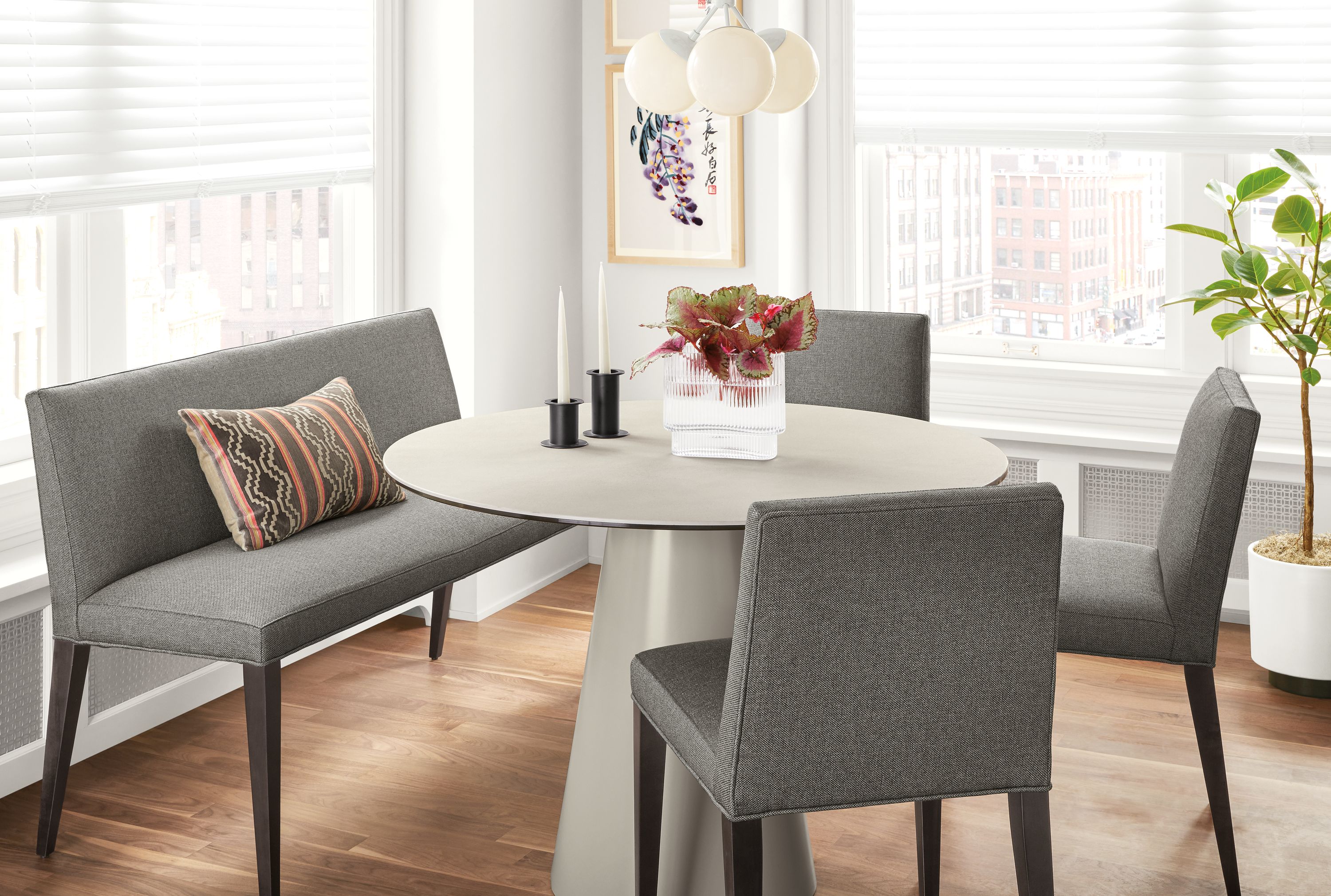 Detail of Ava bench in Sumner Graphite fabric at round table in kitchen with 3 Ava chairs.