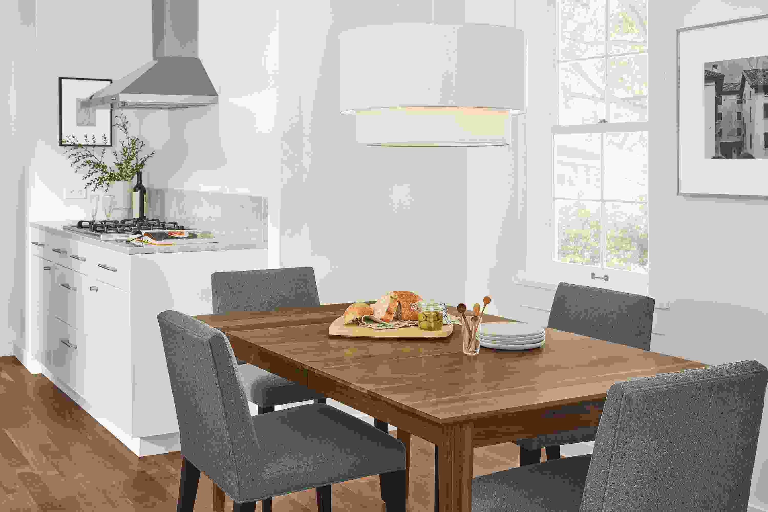 Detail of 4 Ava side chairs in Declan Haze fabric at Adams extension table in walnut.