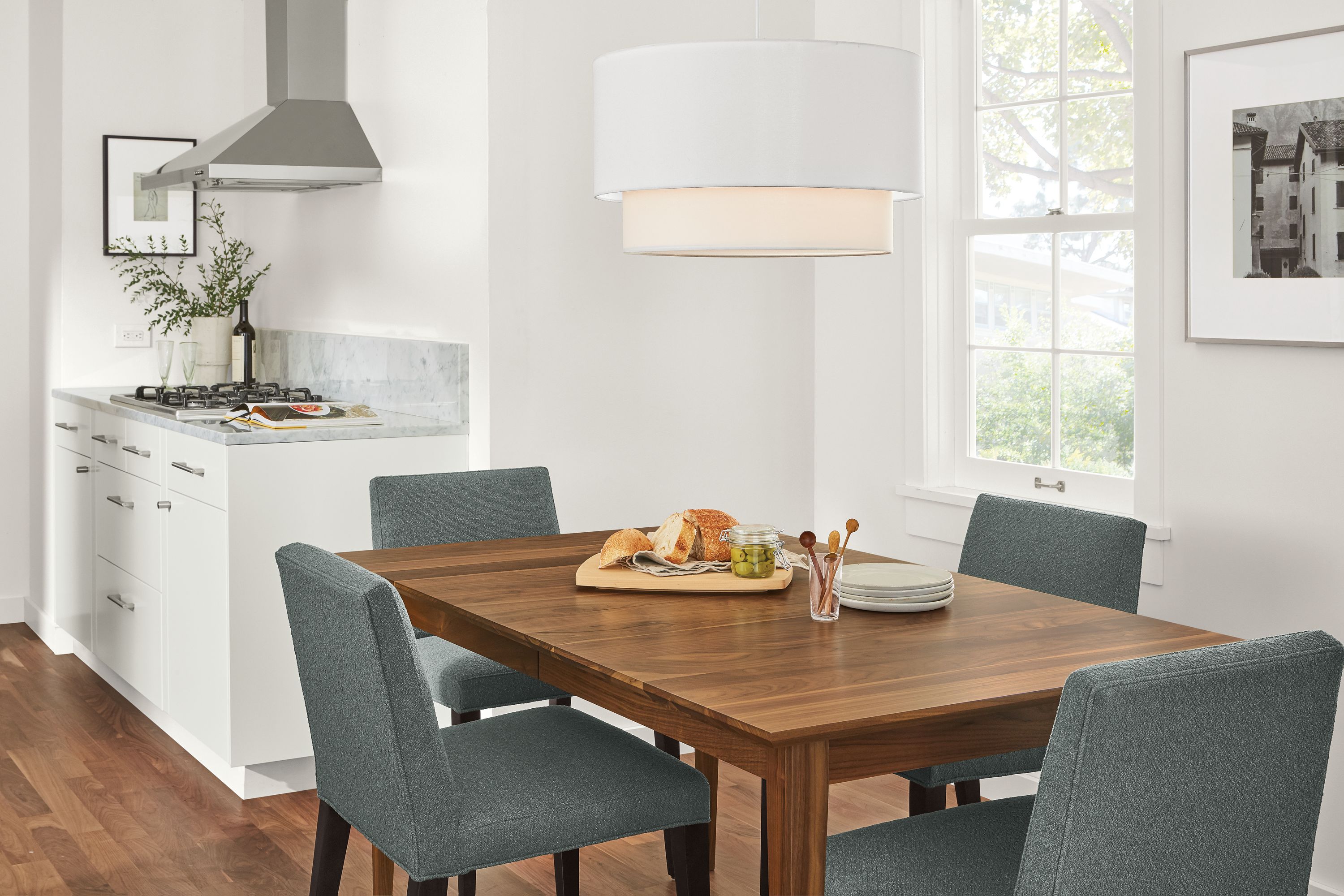 Detail of 4 Ava side chairs in Declan Haze fabric at Adams extension table in walnut.