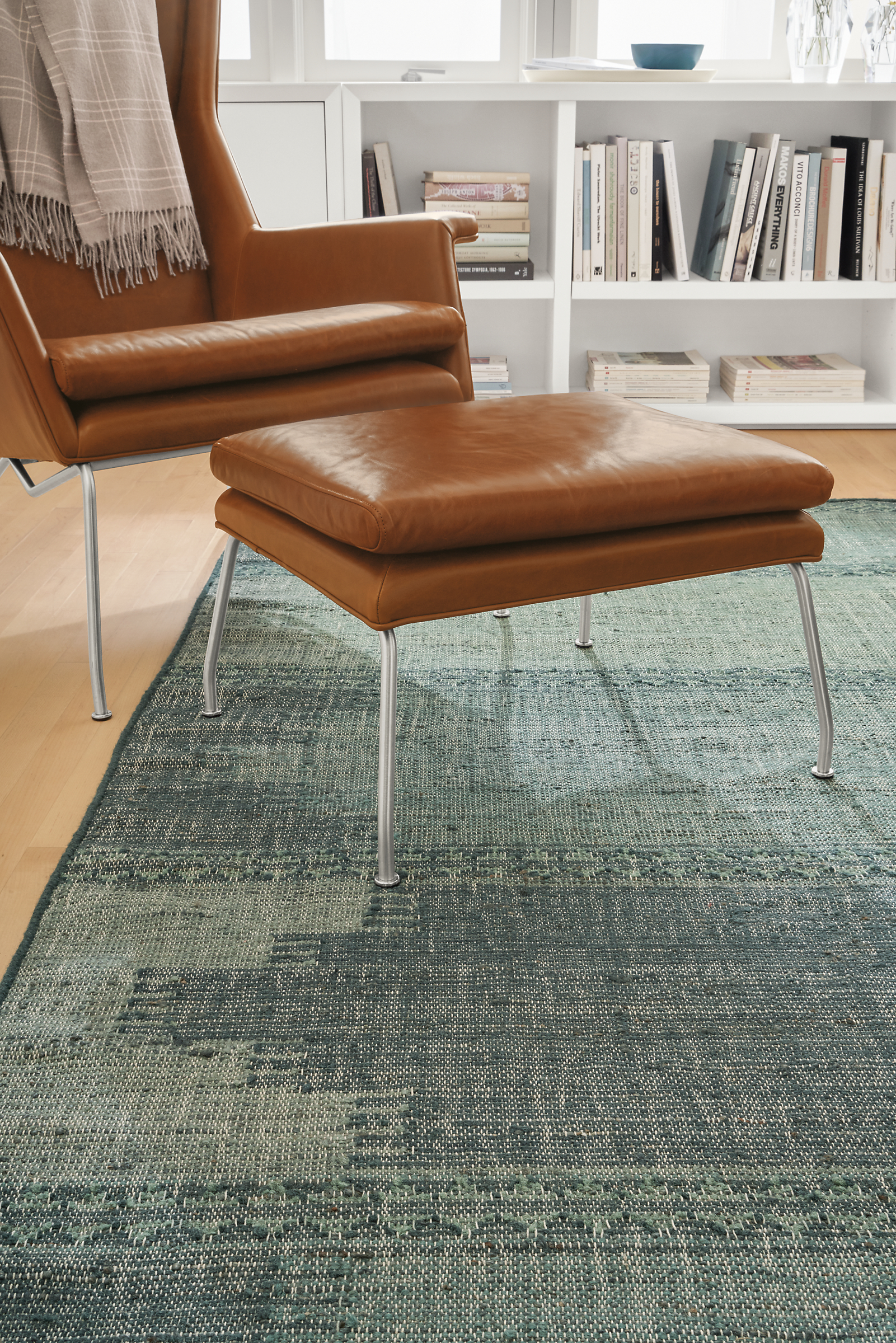 Detail of Avata rug in Turquoise in living room with Aidan leather chair.