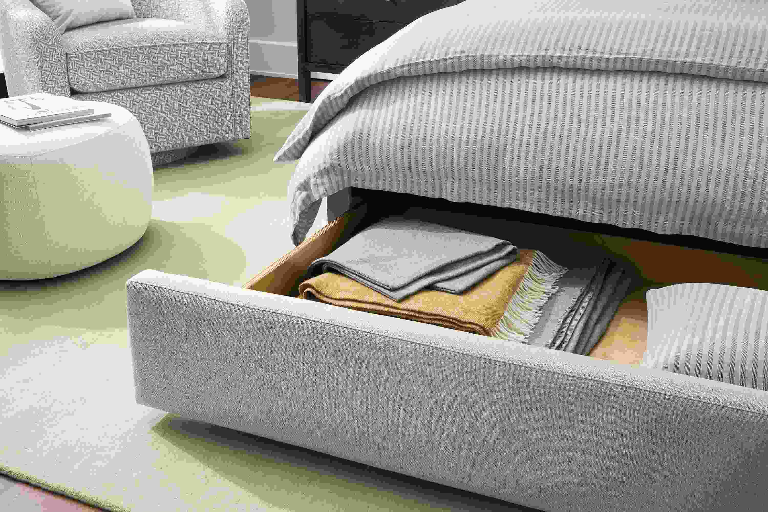 Detail of avery queen storage bed in landedn asphalt shown with storage drawer open.
