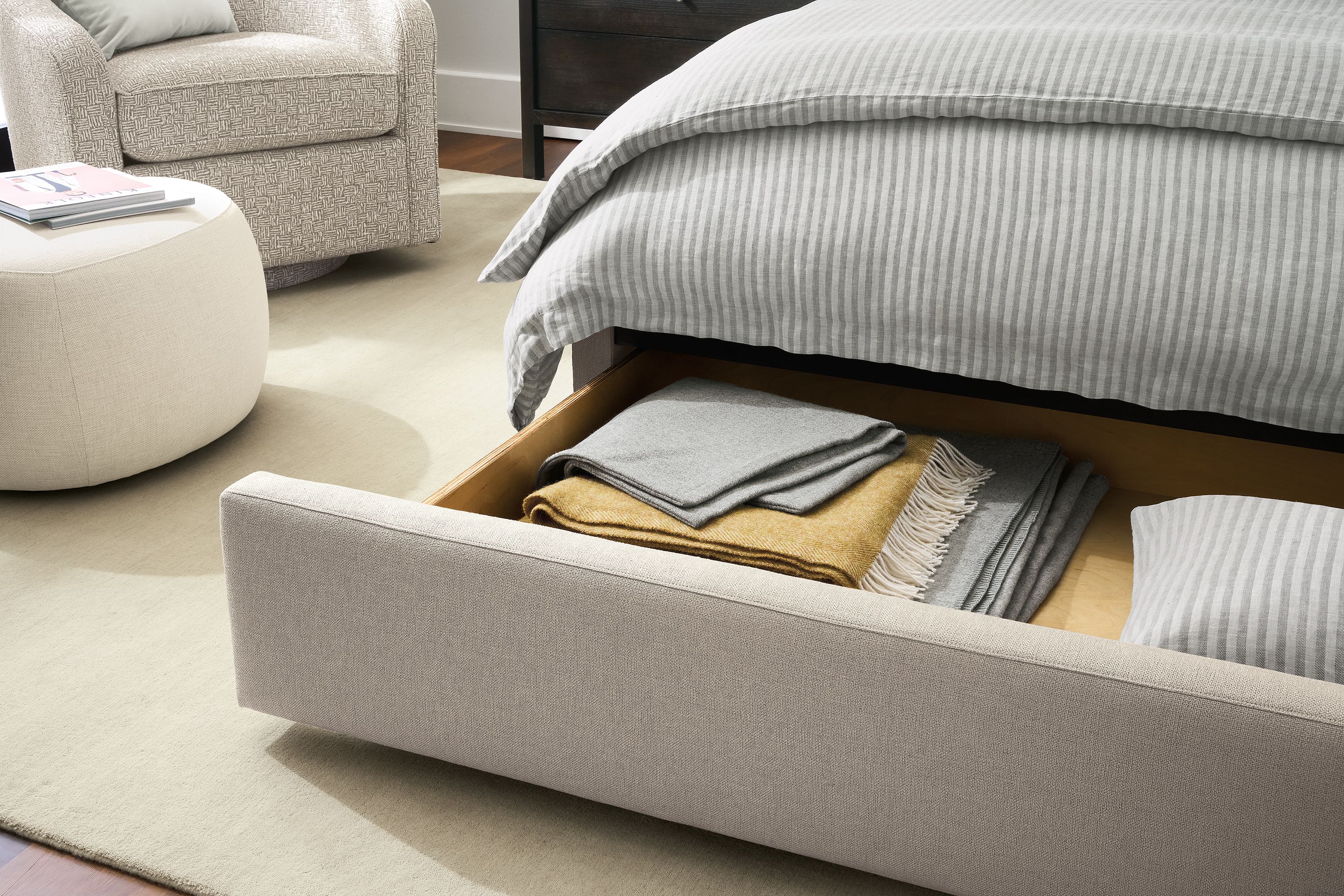 Detail of avery queen storage bed in landedn asphalt shown with storage drawer open.