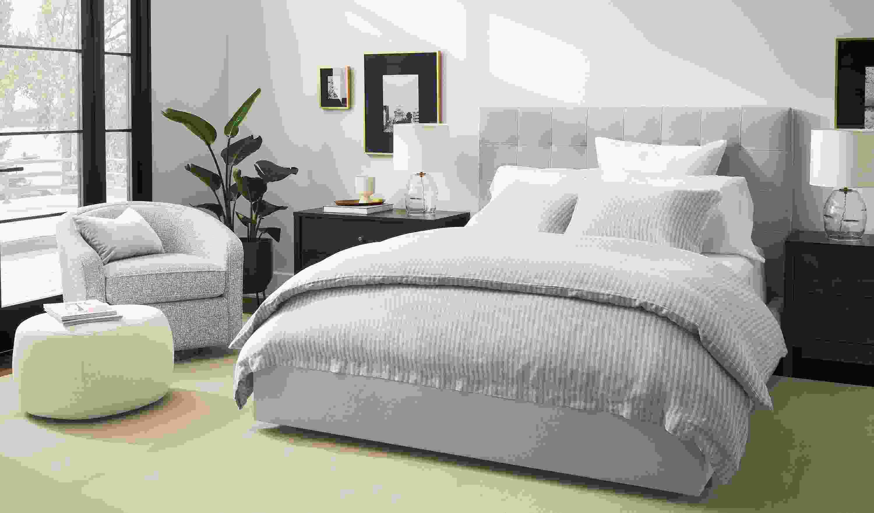 Bedroom with avery queen storage bed in landen asphalt, amos swivel chair in wexford flax and luco rug.