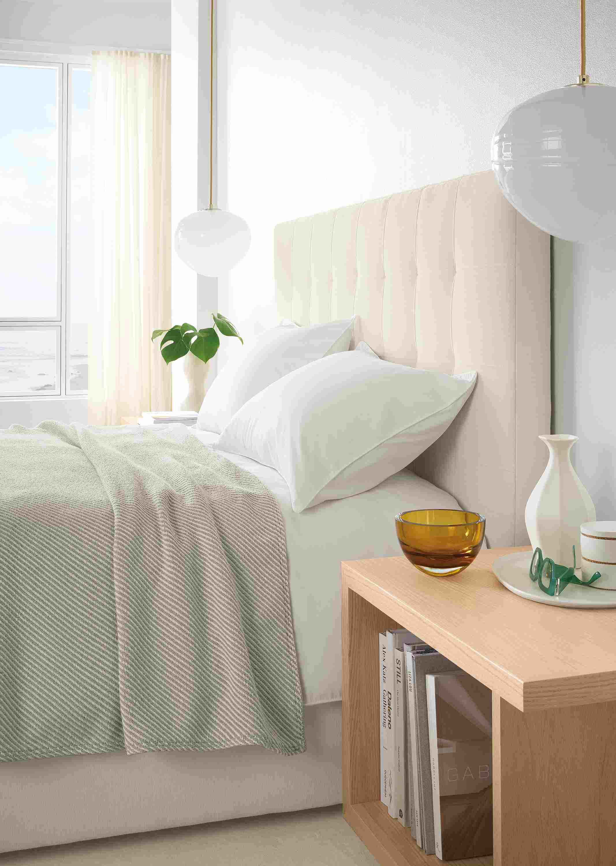 Bedroom with detail of Avery queen storage bed in Mori Ivory and Graham end table in salt on red oak.