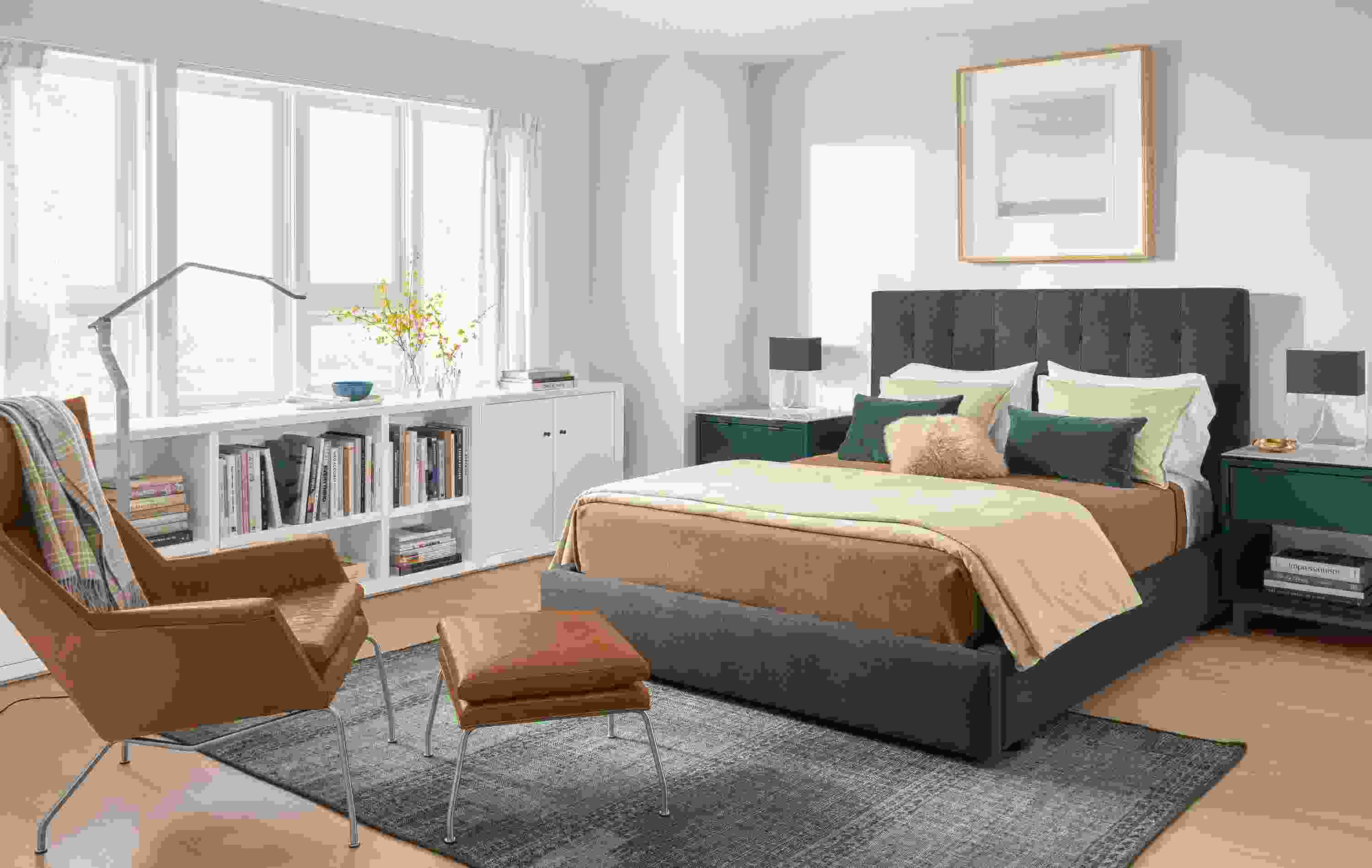 Bedroom with Avery queen storage bed in Gino Charcoal fabric, Aidan chair in Vento Cognac leather,and Lennox bookcases.