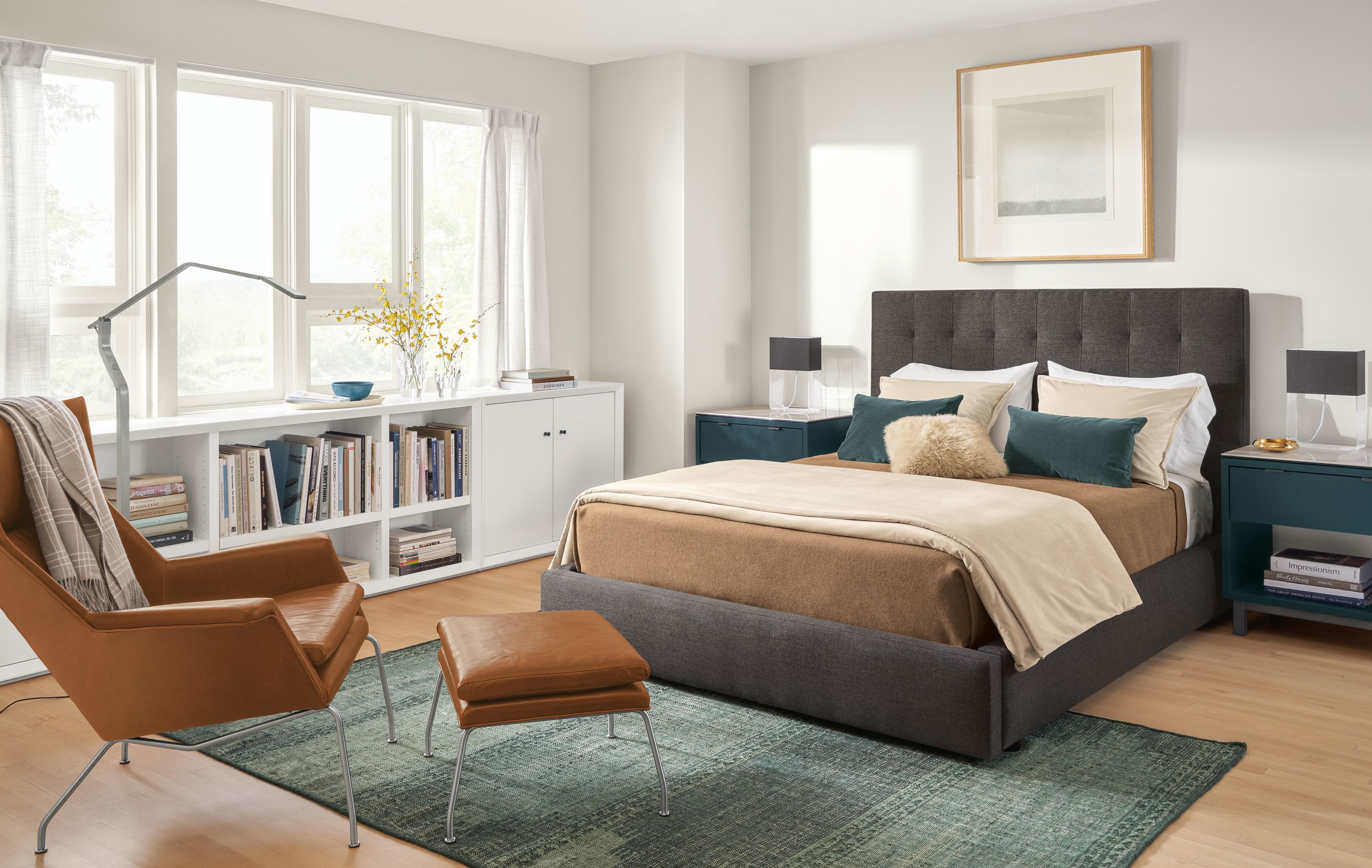 Bedroom with Avery queen storage bed in Gino Charcoal fabric, Aidan chair in Vento Cognac leather,and Lennox bookcases.