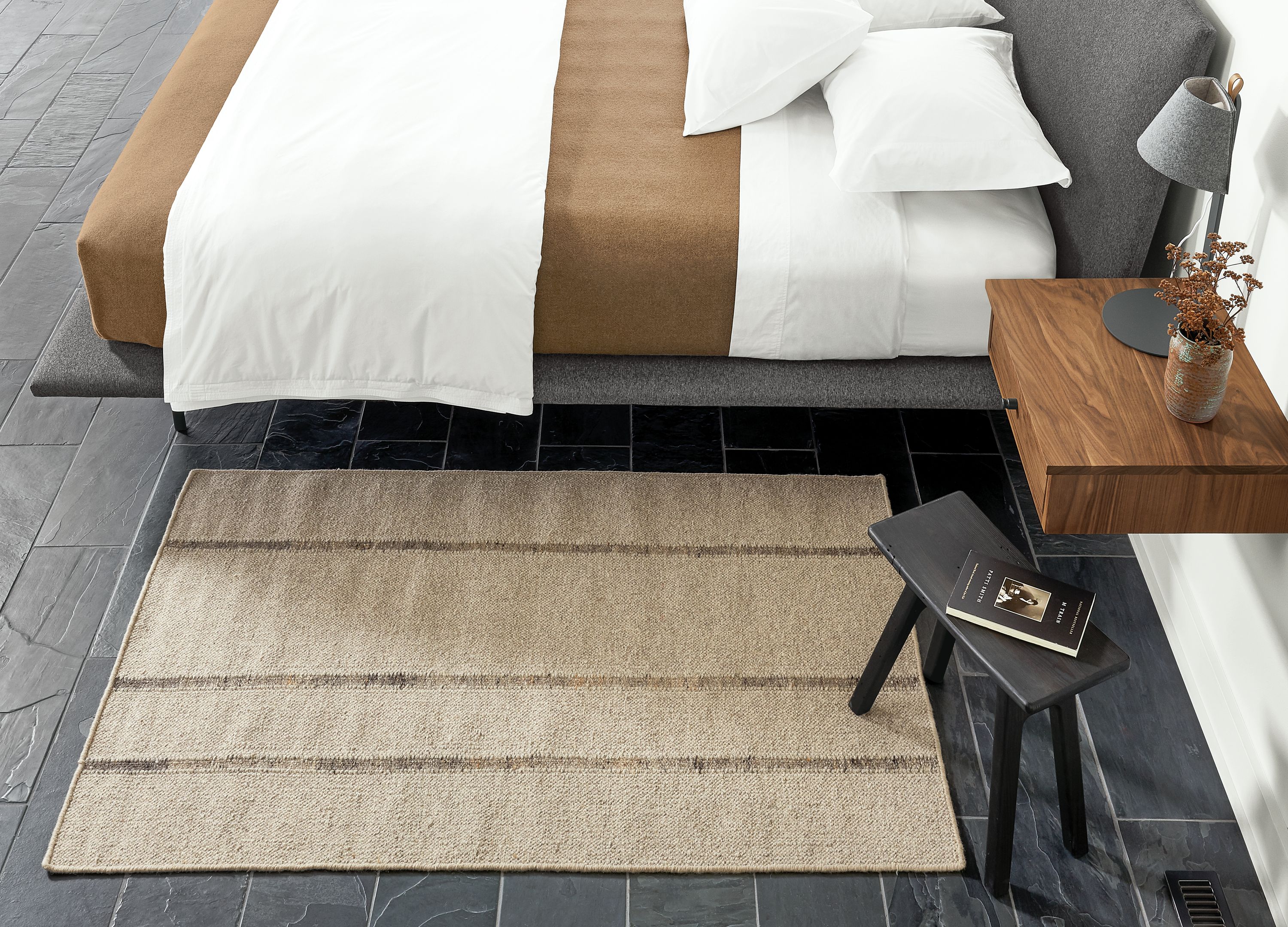Detail of Bambu rug in Taupe in bedroom beside bed.