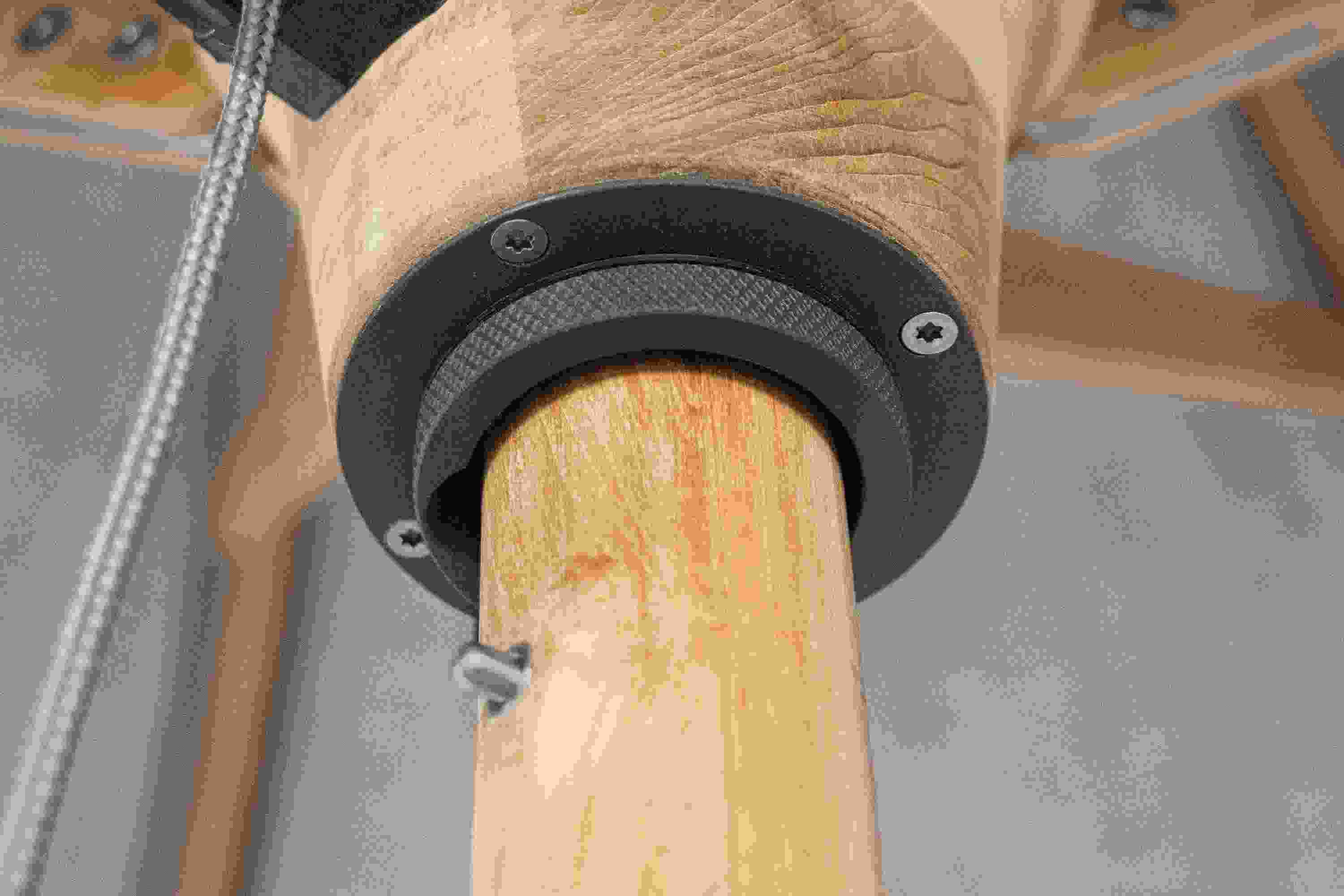 Detailed view of the runner hub on a Banda 10-foot round patio umbrella in Halo Grey and Teak Hardwood.