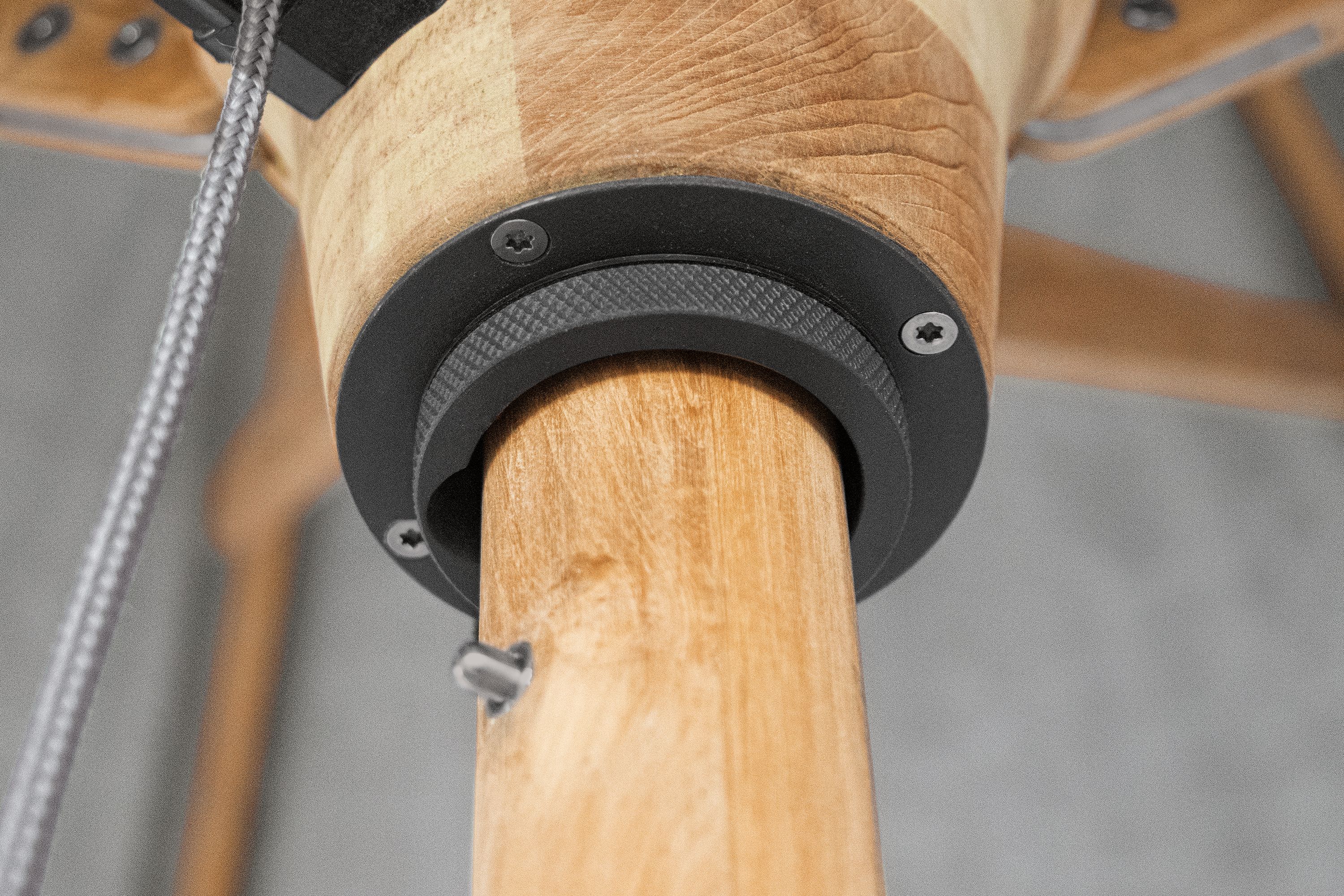 Detailed view of the runner hub on a Banda 10-foot round patio umbrella in Halo Grey and Teak Hardwood.