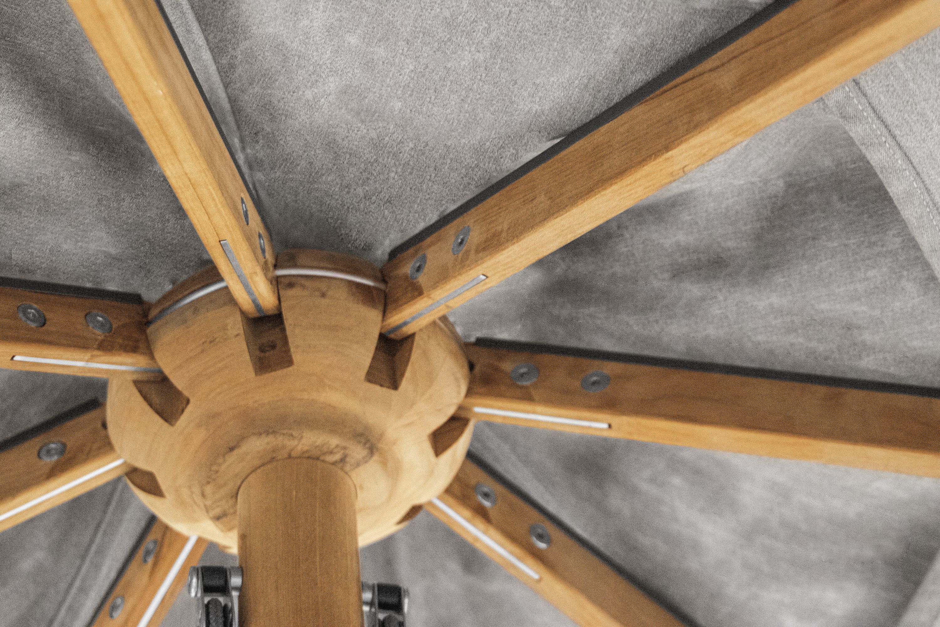 Detailed view of the wooden rib assembly on the underside of a Banda 10-foot round patio umbrella in teak.