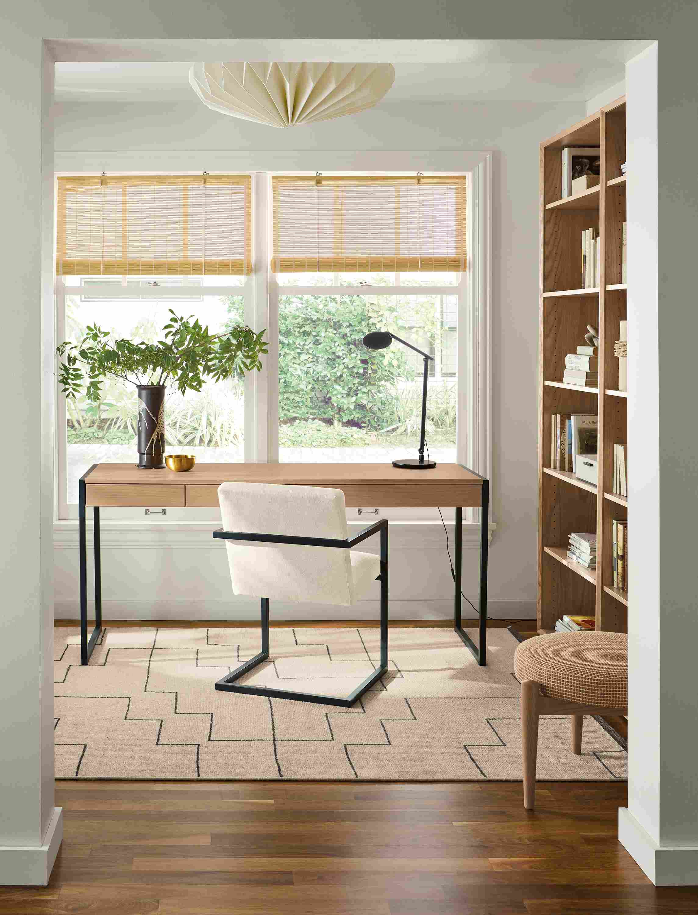 Home office with Basis 66-wide, 2-drawer desk in rye on red oak and Lira arm chair in Sumner Ivory.