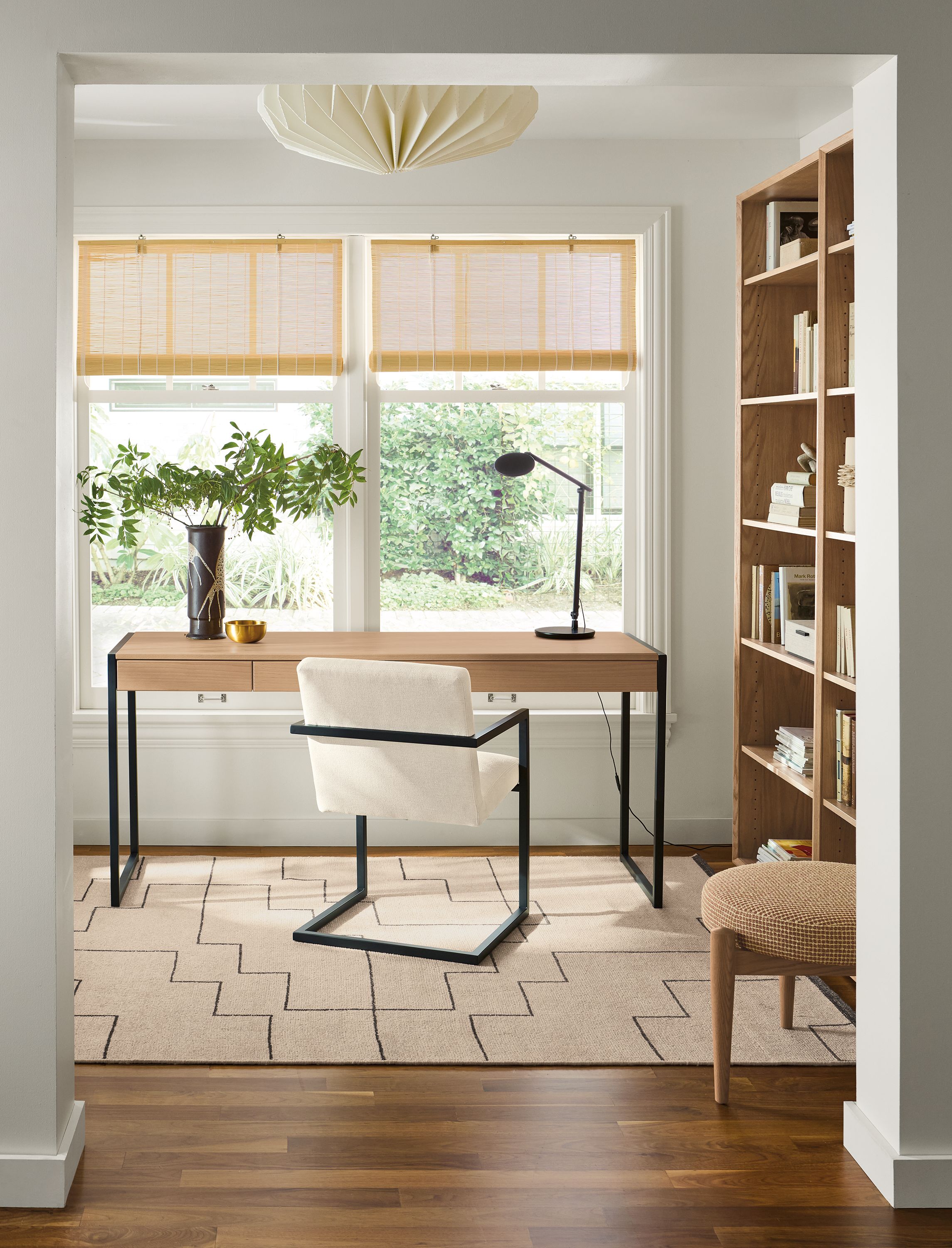 Home office with Basis 66-wide, 2-drawer desk in rye on red oak and Lira arm chair in Sumner Ivory.