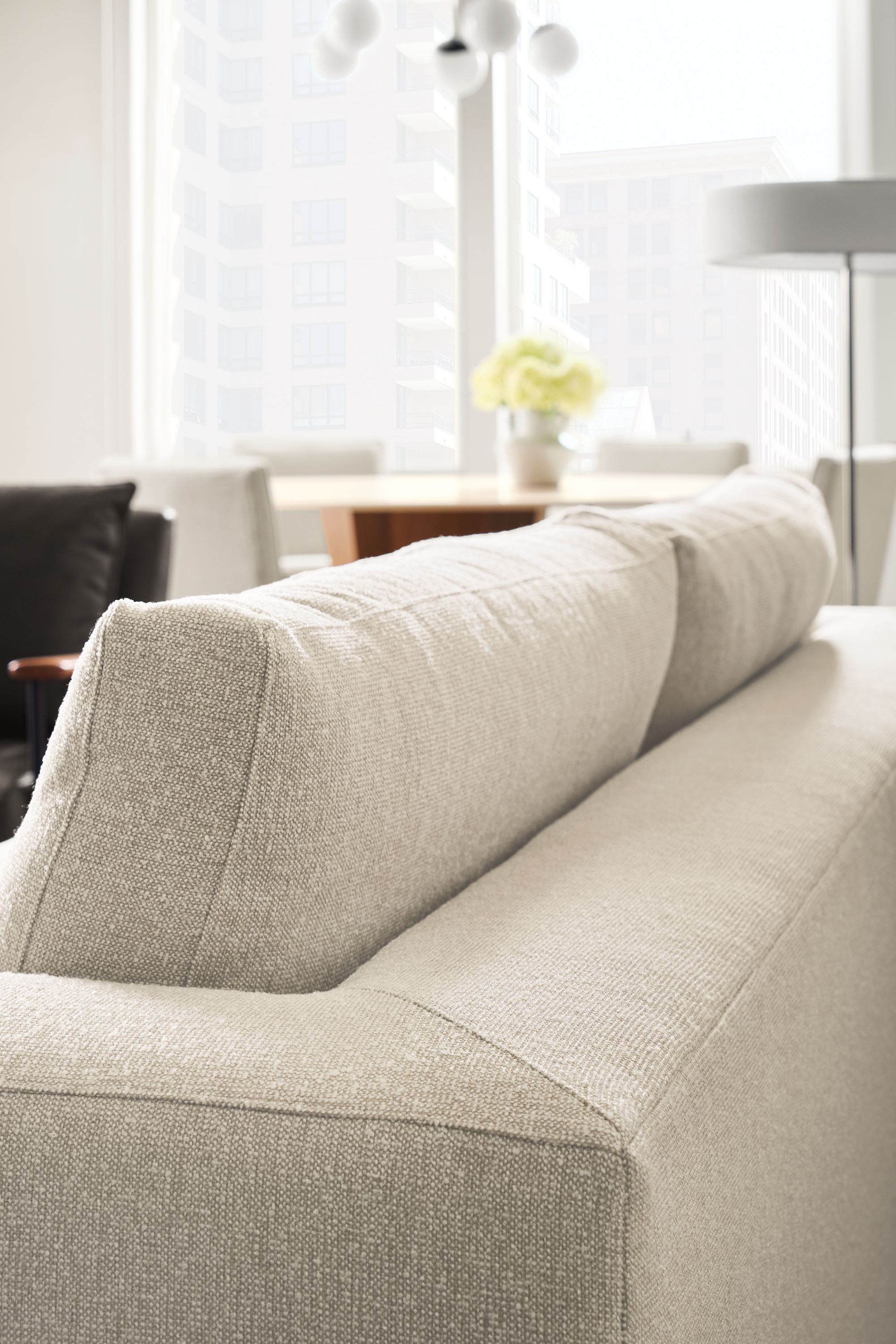 Living room with detail of backside of cushions on a baylor sofa in conley natural fabric.