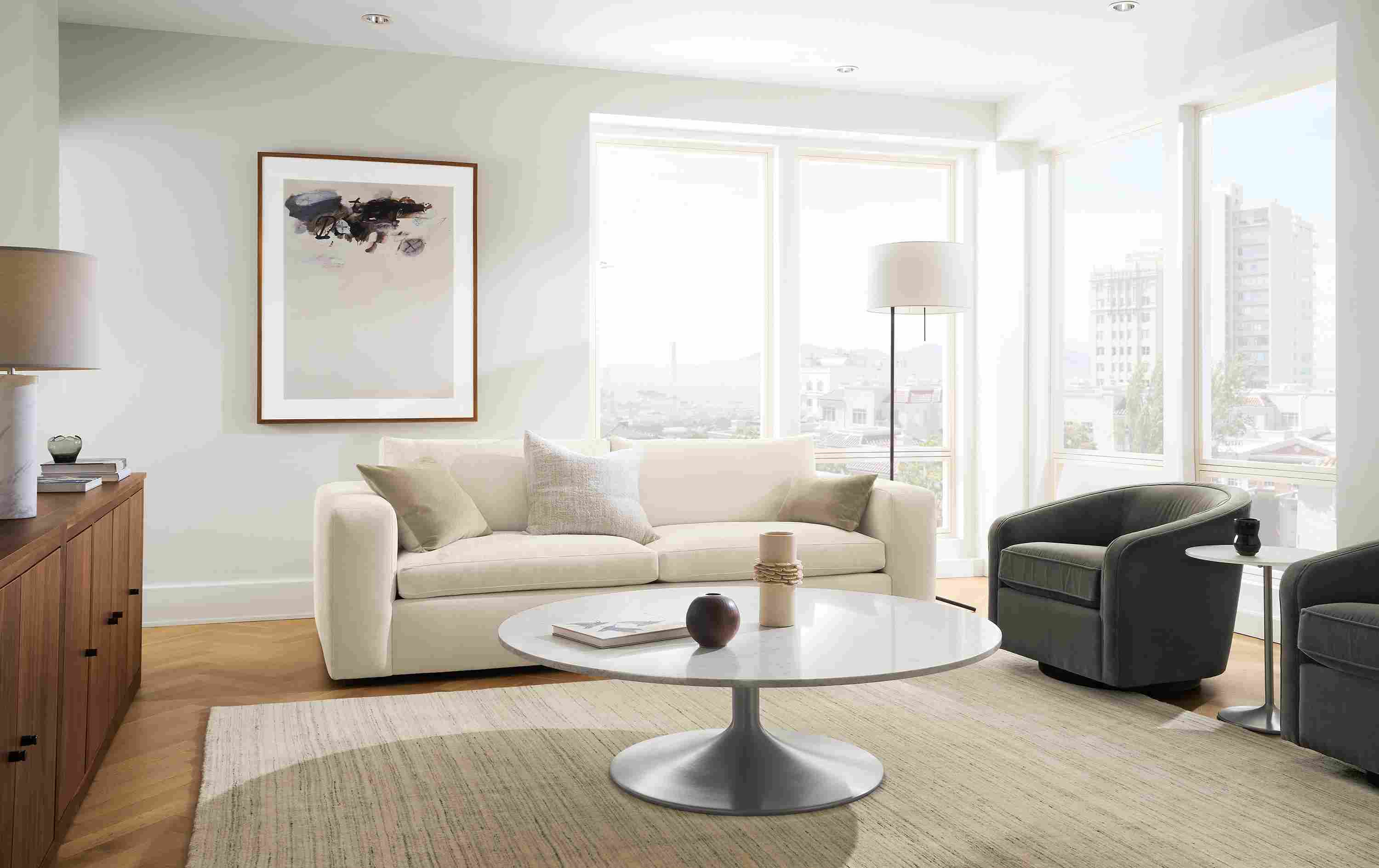 Living room with baylor 98-wide sofa in mori ivory, 2 amos swivel chairs in banks charcoal and nomad 8 by 10 rug in ivory/grey.